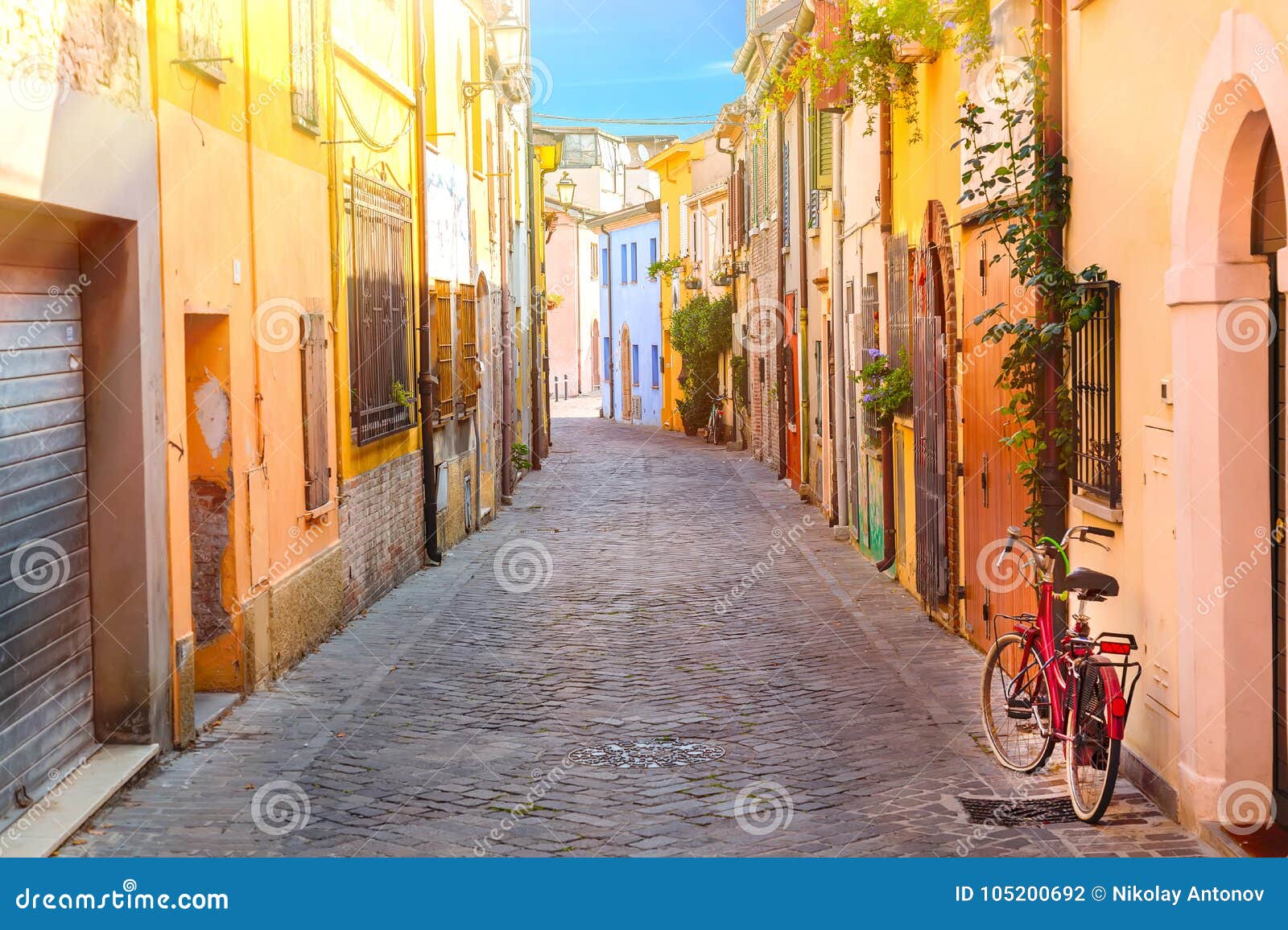 narrow street of the village of fishermen san guiliano with colorful houses and a bicycle in early morning in rimini, italy