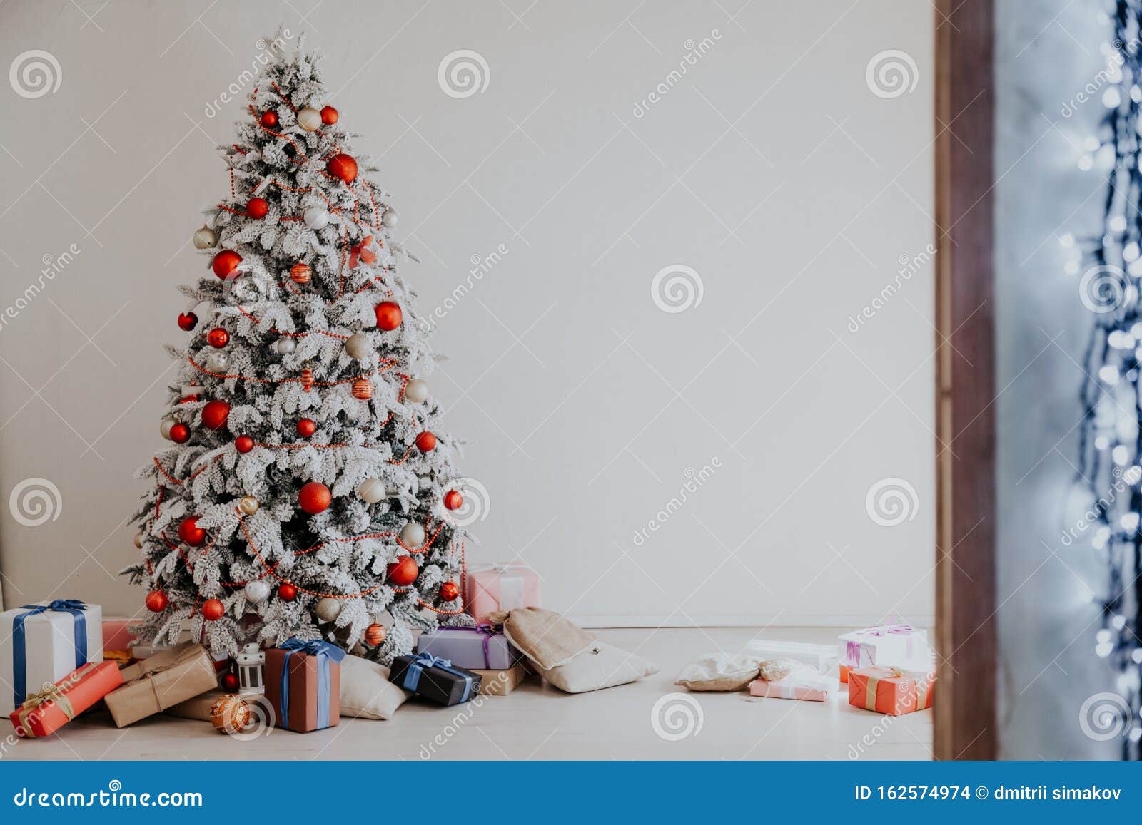 Árvore de natal com neve branca com decoração de presentes no interior da  casa de ano novo