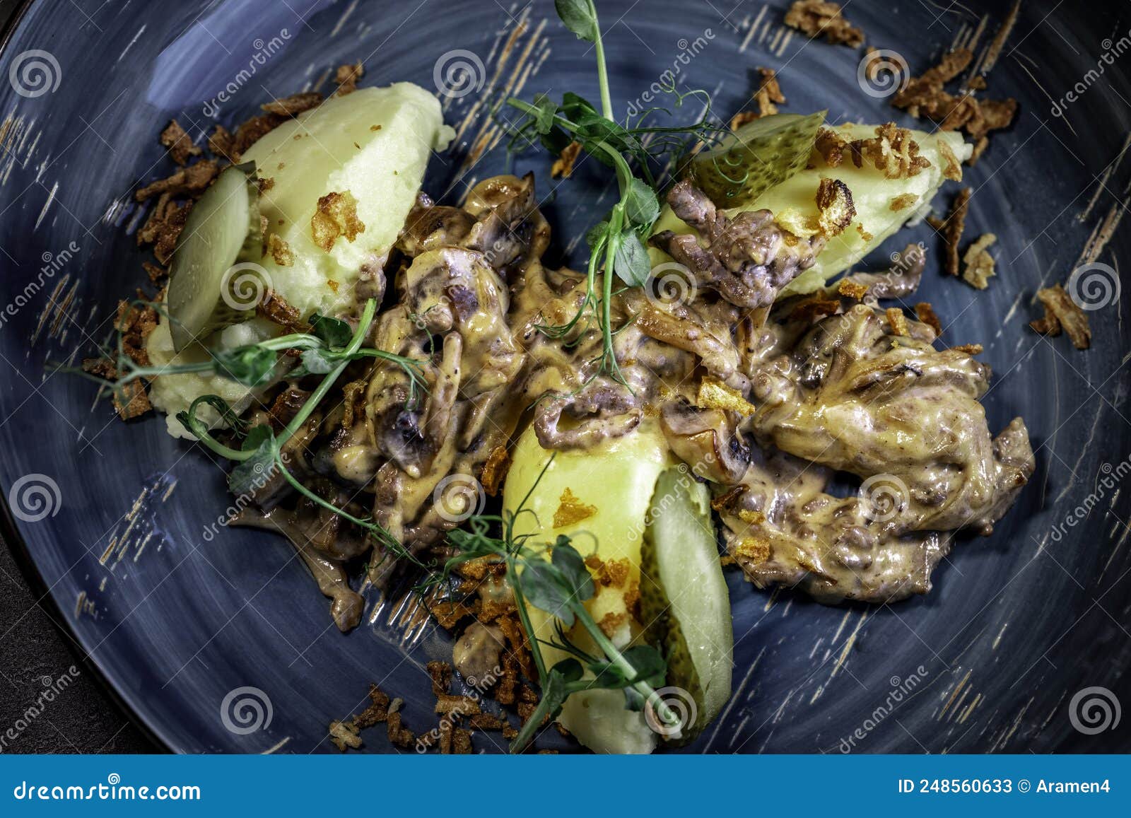 national russian dish of beef stroganoff with meat, boiled potatoes, mushrooms and fried onions.