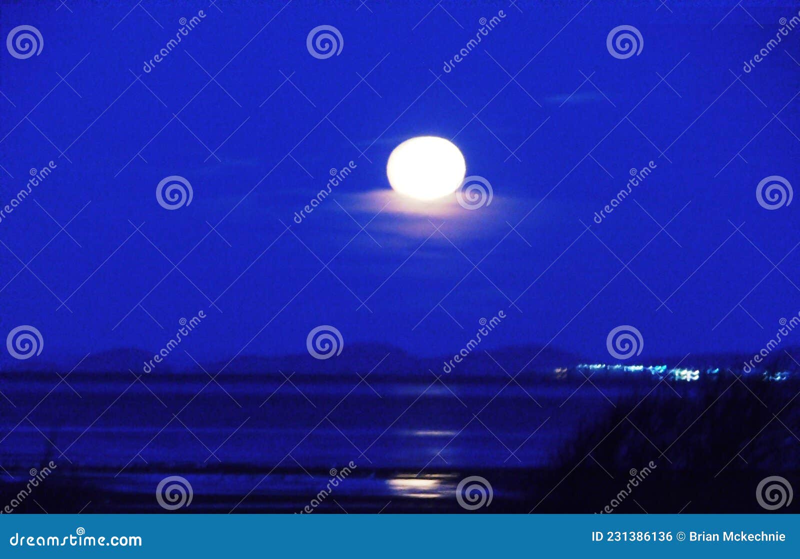 Full Cold Moon Setting Over Barassie Bay South Ayrshire Scotland. Stock