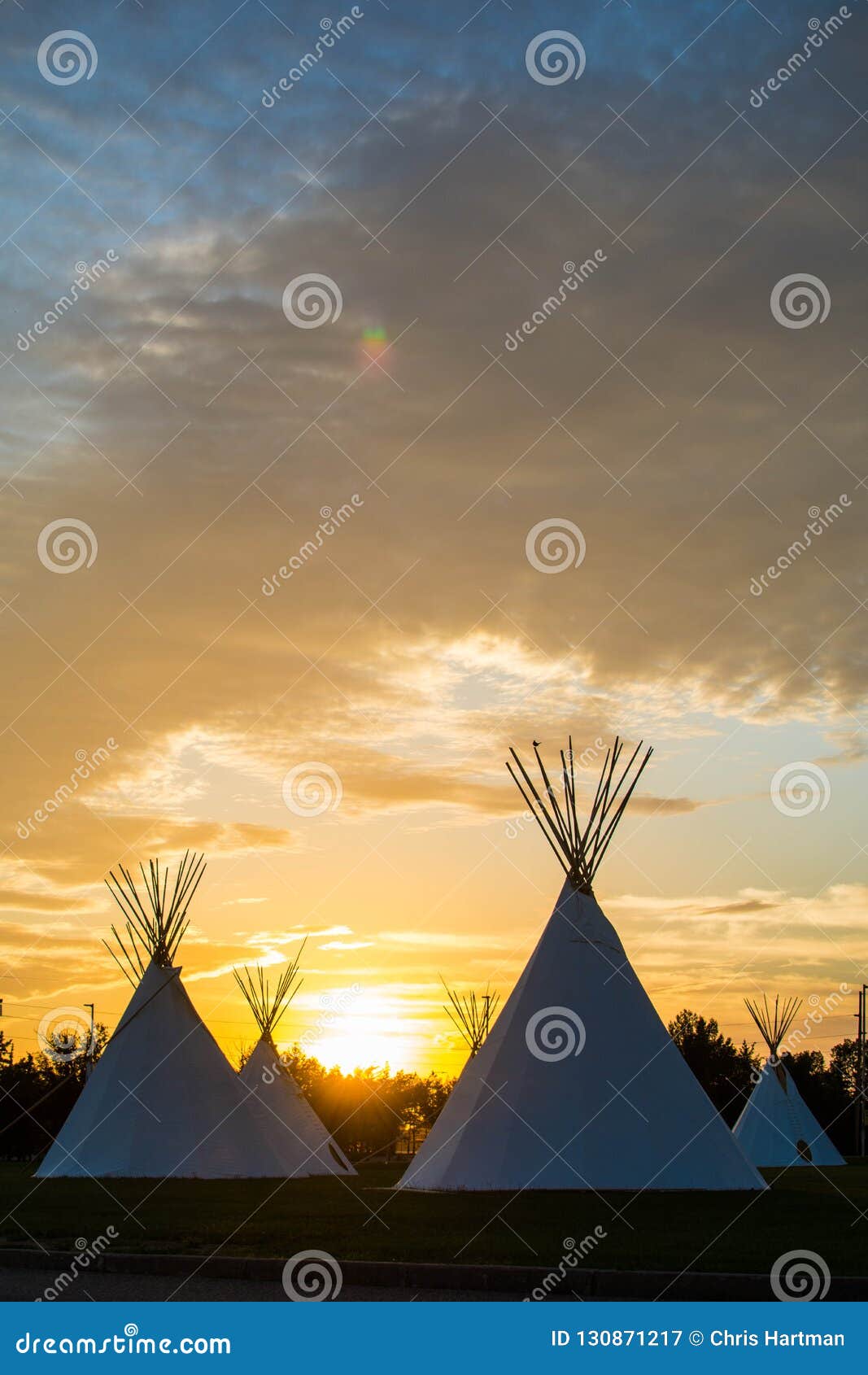 native american tepees on the prairies at sunset