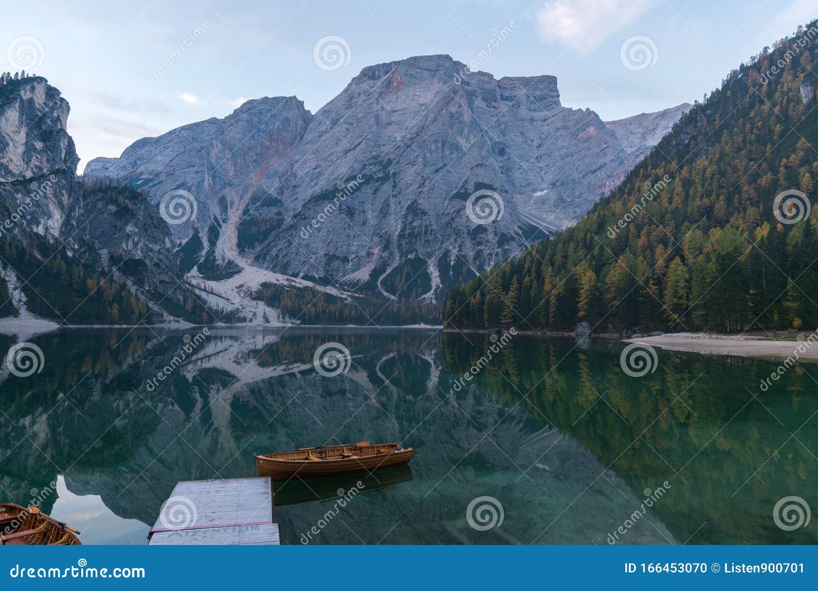 natural landscapes of the lake braies lago di braies with morning fog and reflection of the mountain peak in dolomites, italy