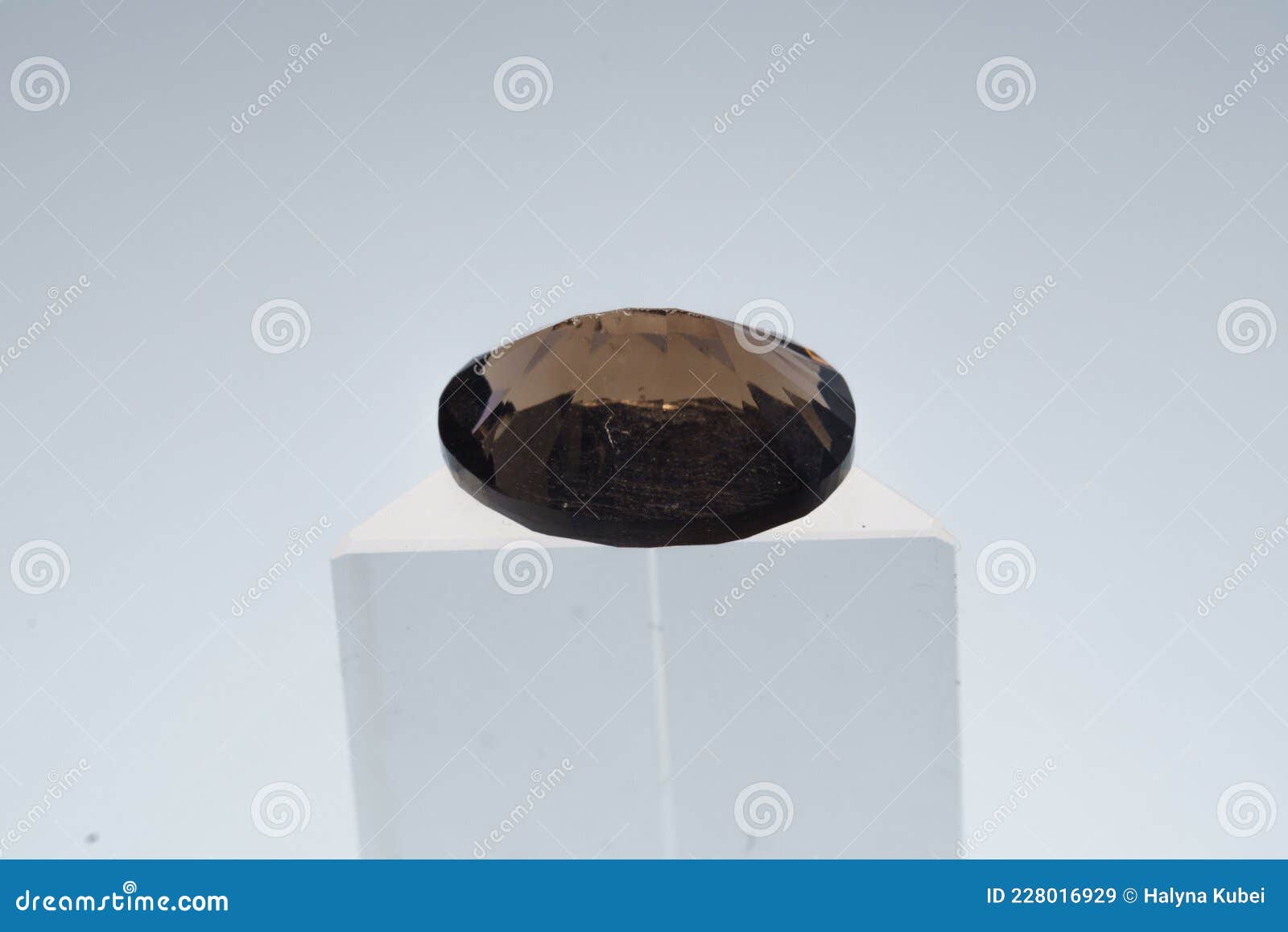 natural smoky quartz stone on a stand on a white background