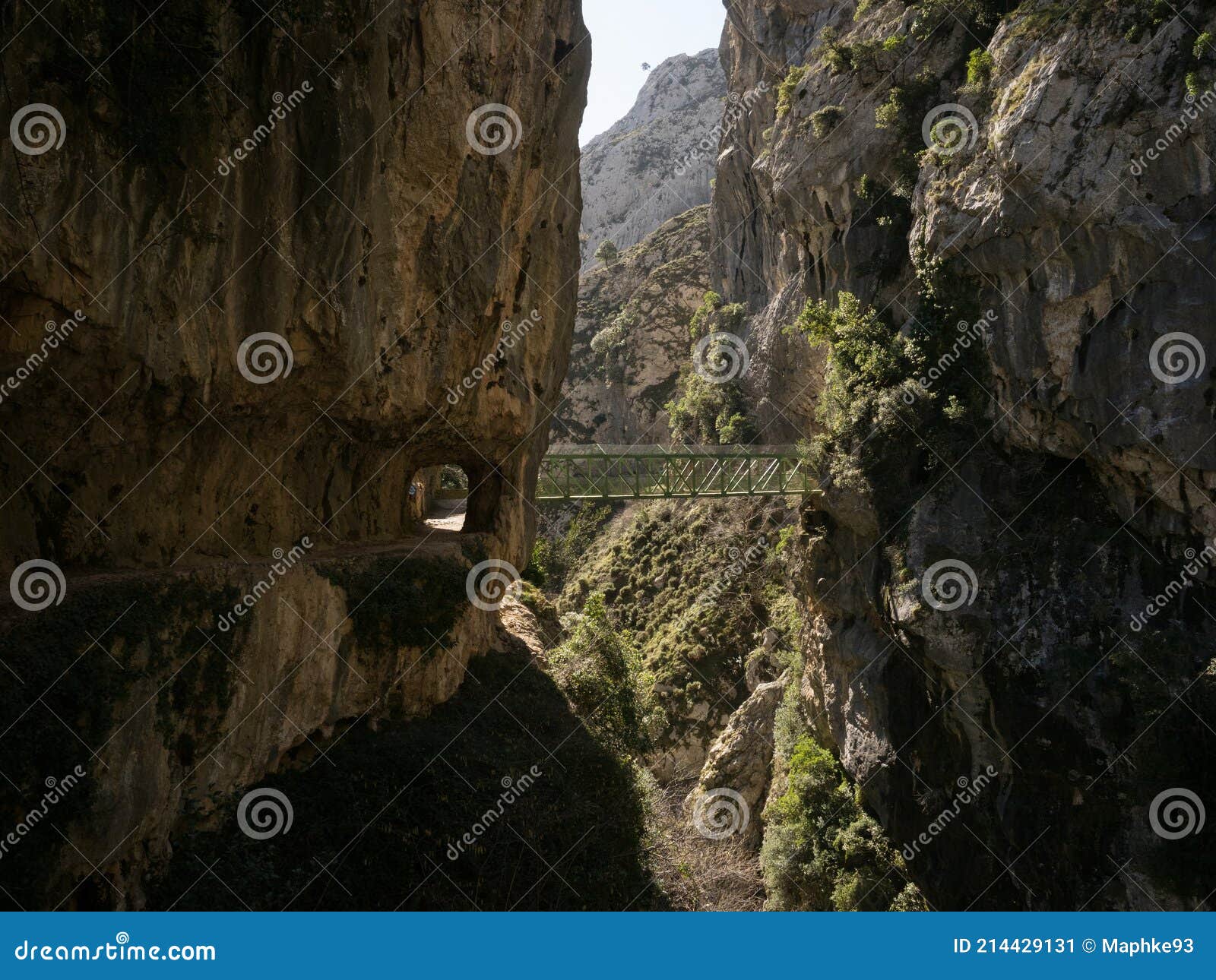 natural tunnel and green steel bridge on hiking trail path senda del cares canyon in picos de europa mountains spain