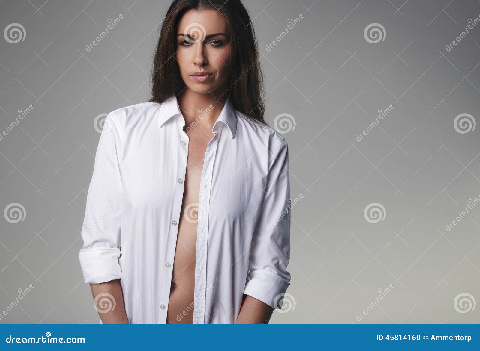 Photo about Natural young woman wearing an unbuttoned shirt and looking at ...
