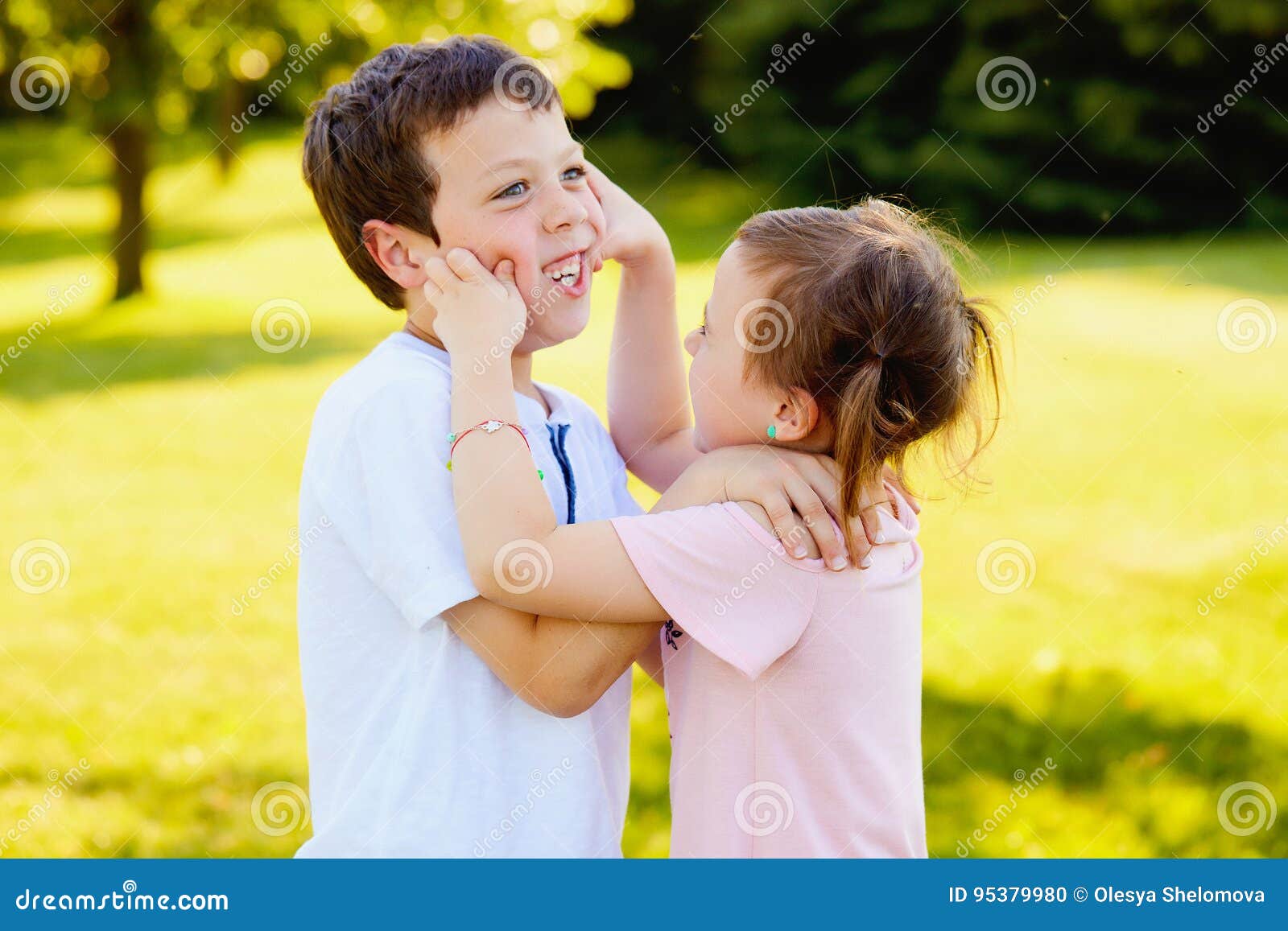 Naughty Little Girl Pinching Cheeks Of Her Brother Stock Photo Image
