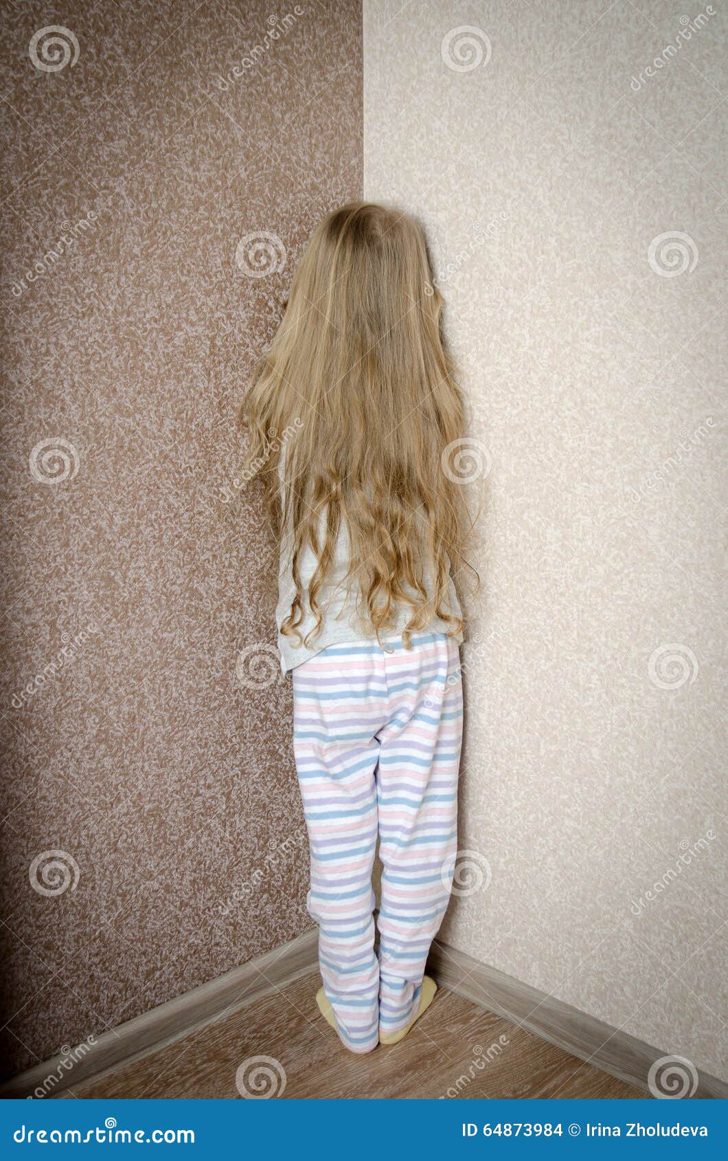 Naughty Little Girl Is Standing In The Corner Punished Stock Photo