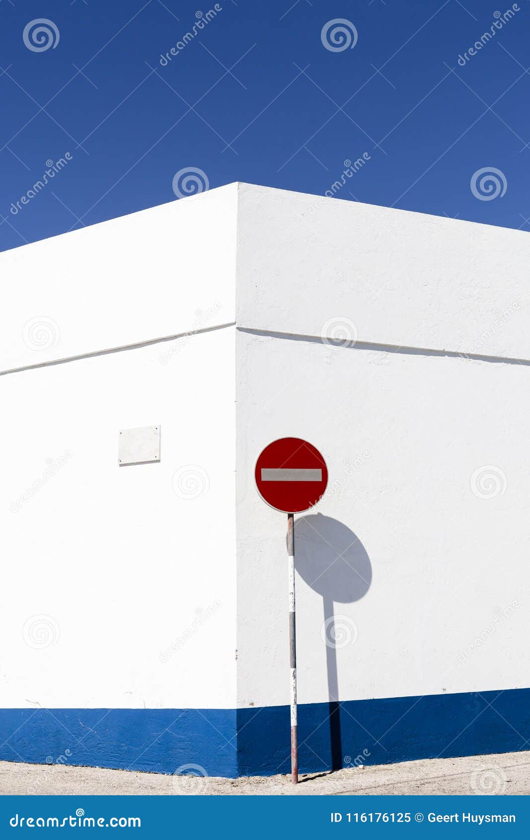 nazare, portugal - july 14, 2017. white wall with no entry traffic sign, against a blue sky.