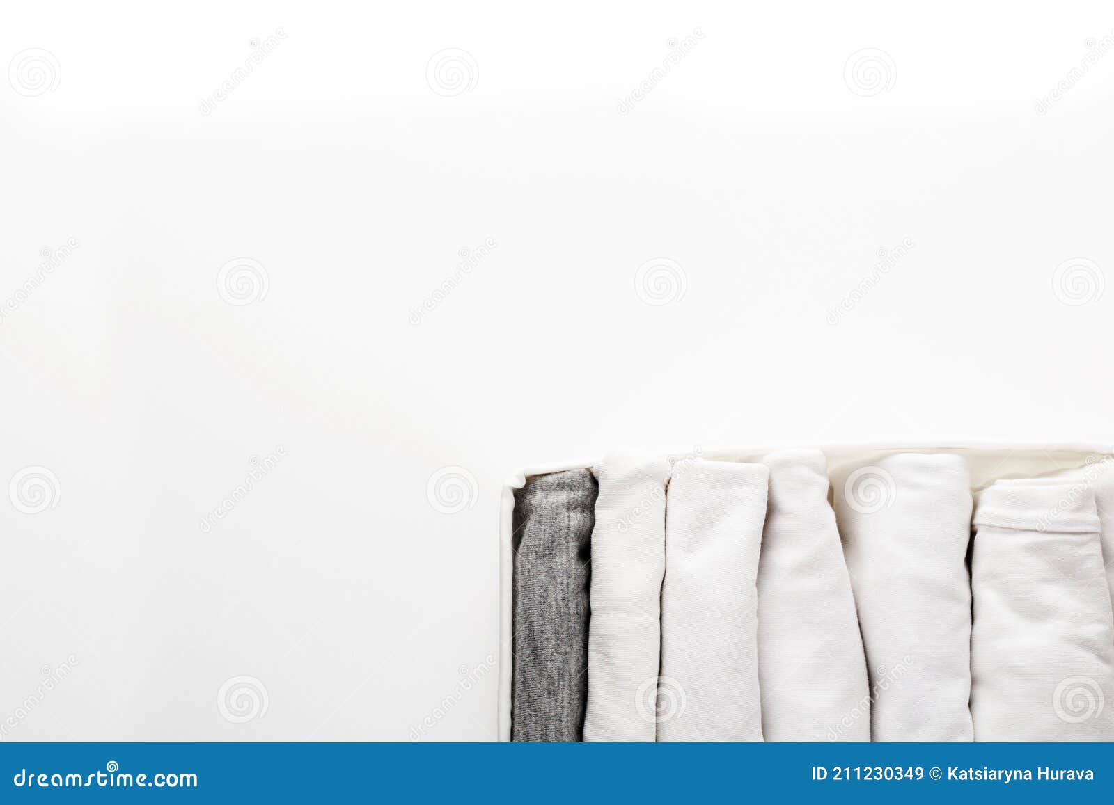 Neatly Folded White and Gray Clothes in a Container for a Wardrobe or