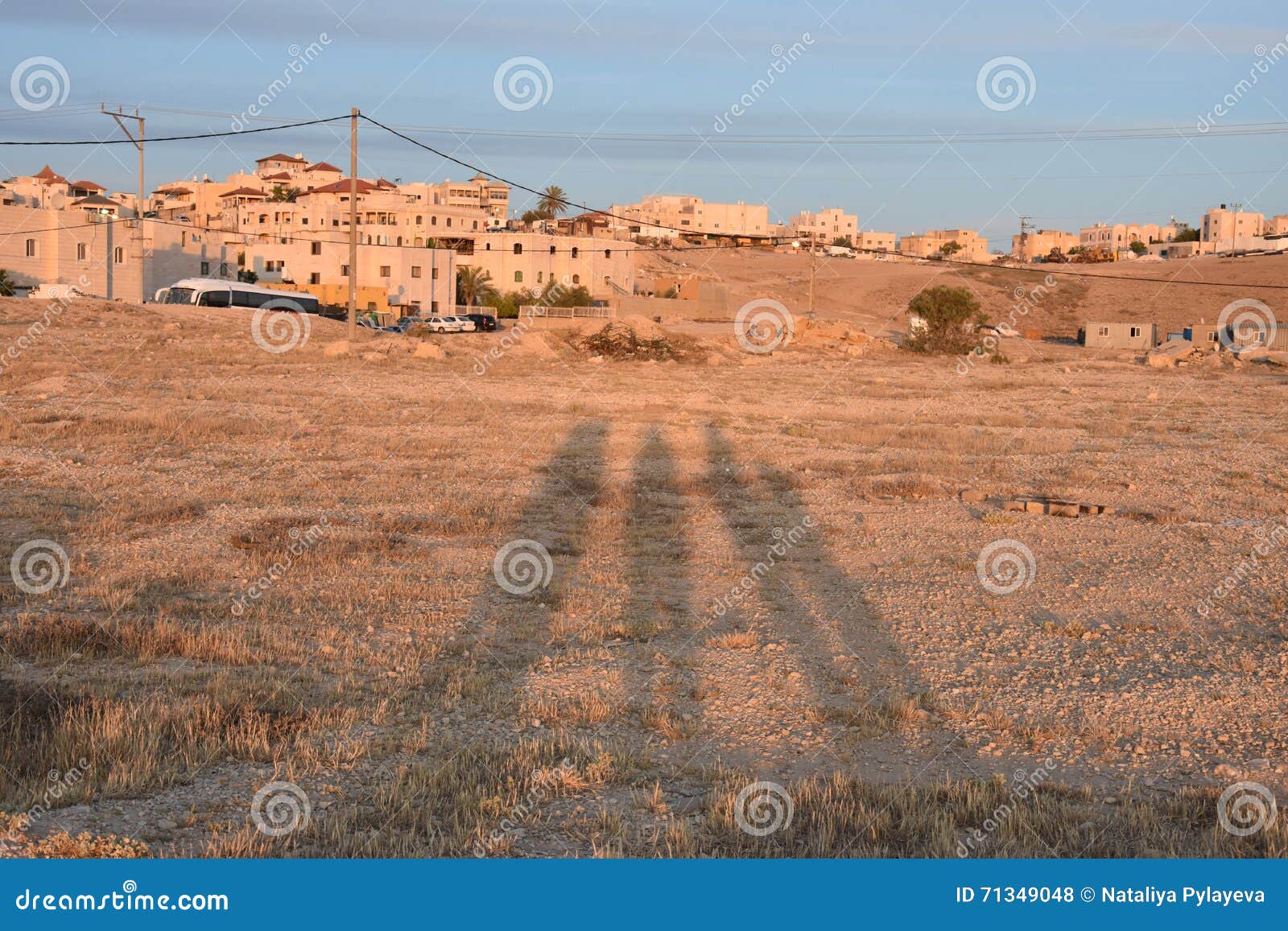 negev desert, arar settlement, three human shadows on the sand at sunset