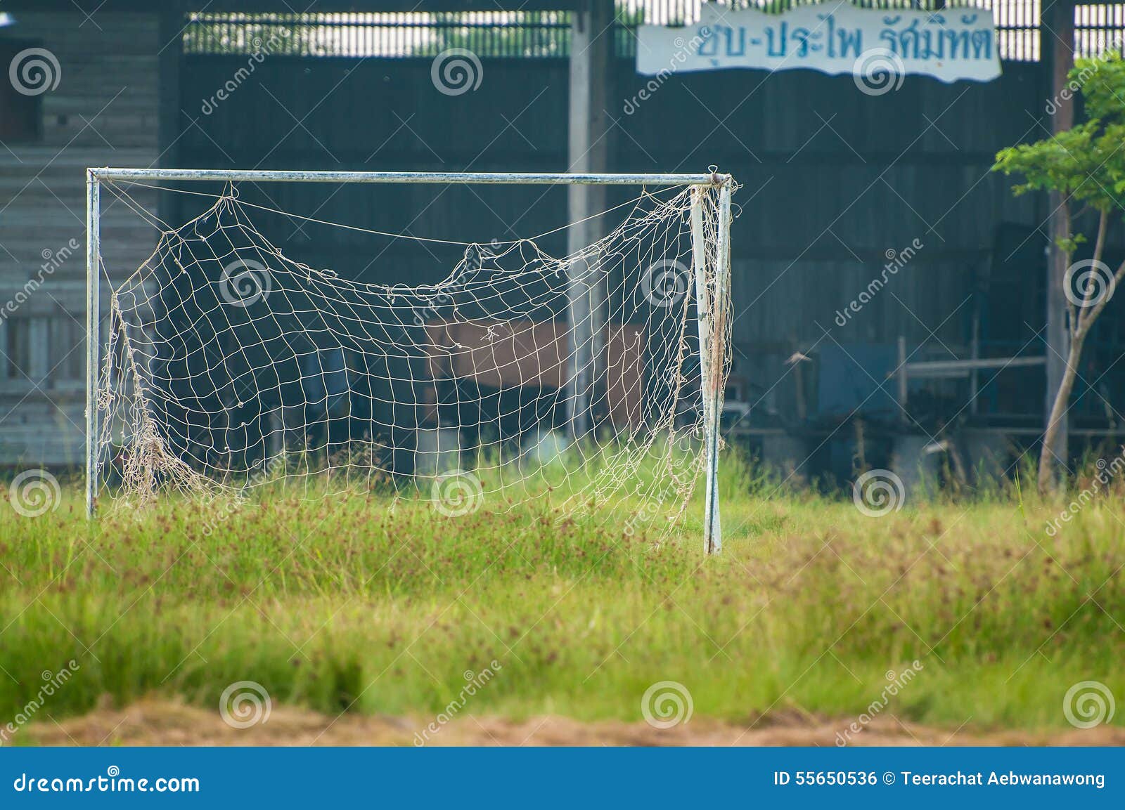 neglected empty soccer football net on field , unused, dilapidated , old goal