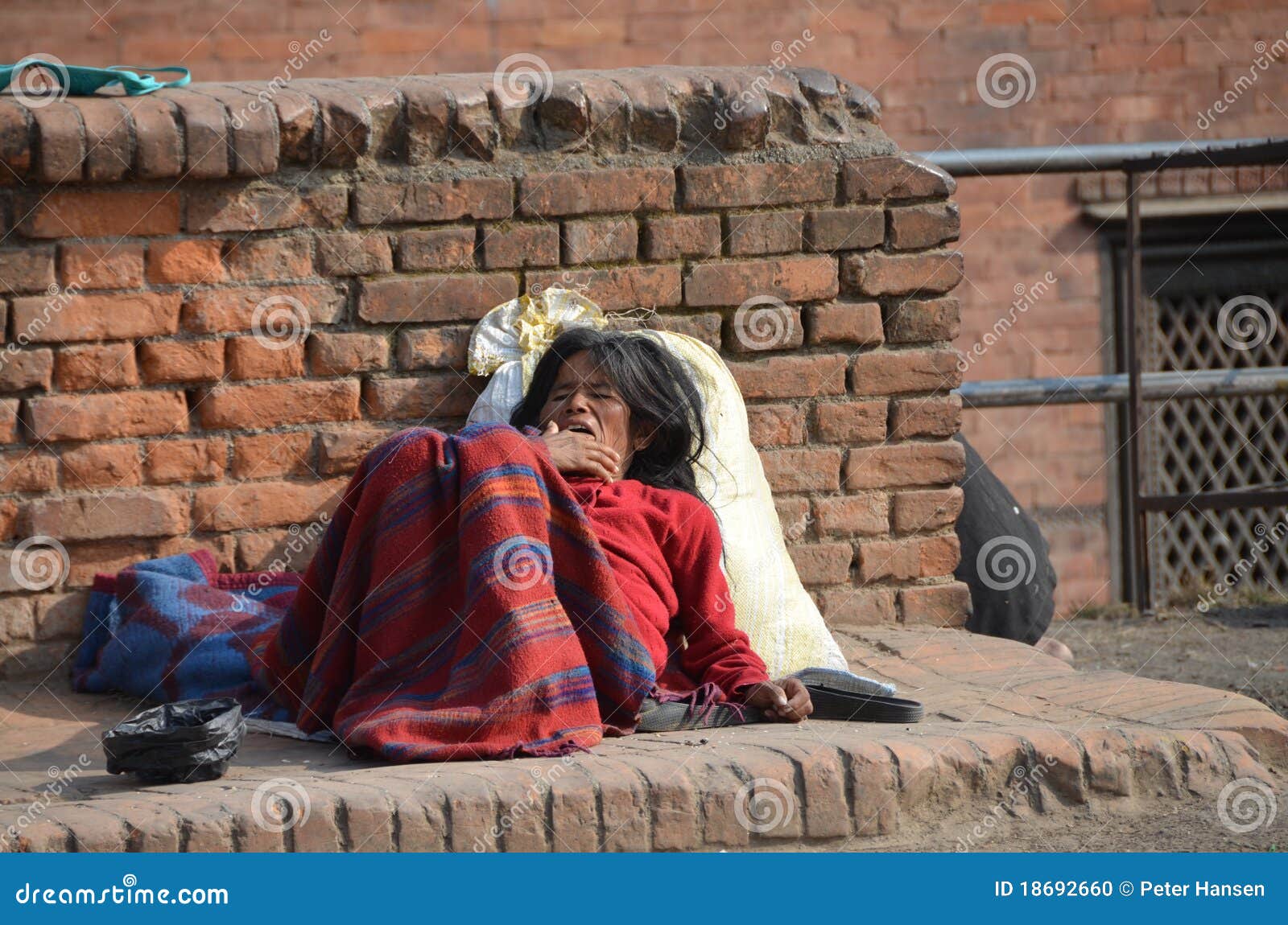 Nepalese poor woman is sitting on a step