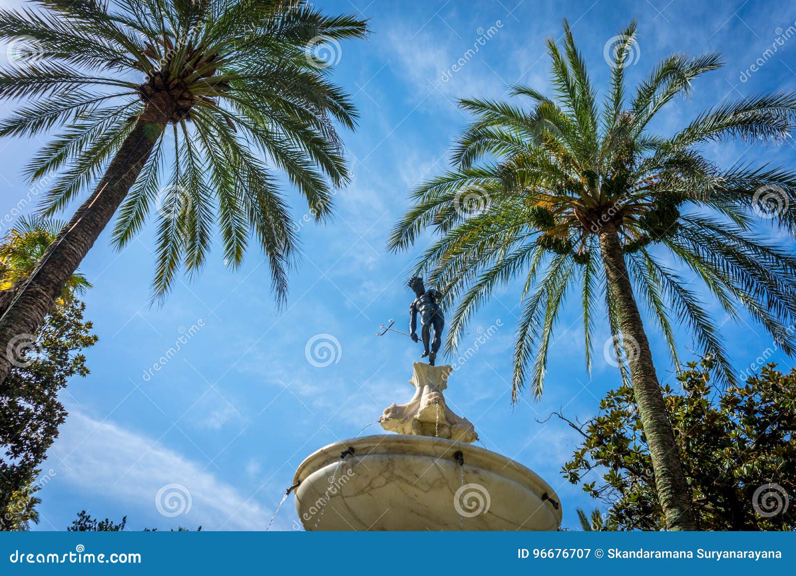 Neptune Under the Palm Tree in Alcazar Garden with a Blue Sky in Stock ...