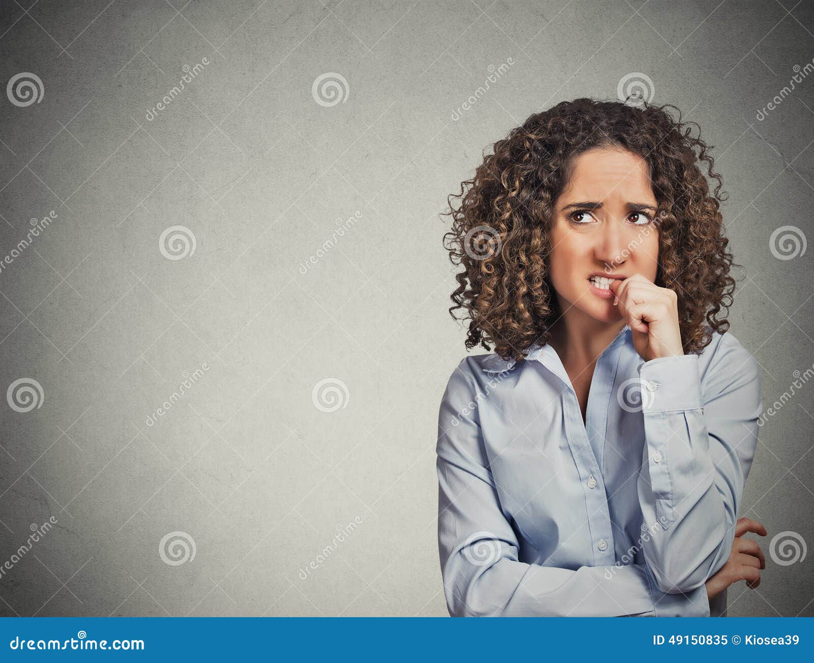 nervous looking woman biting her fingernails craving something