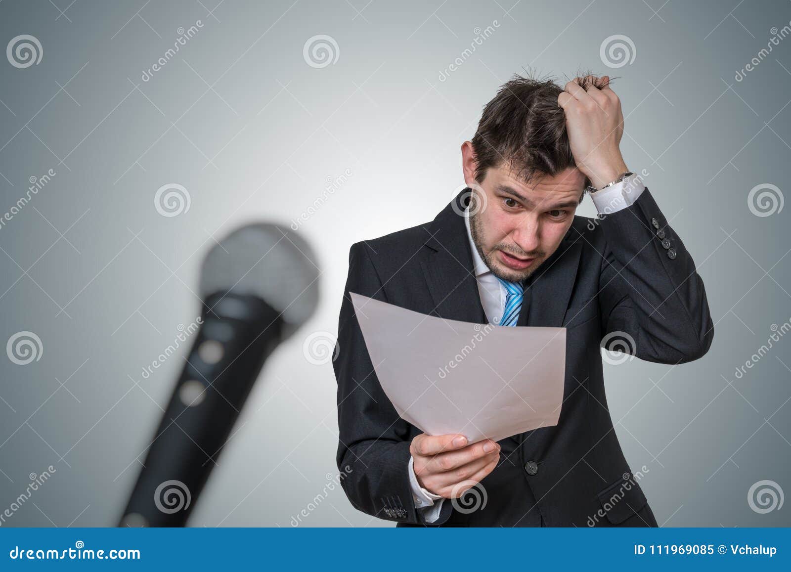 nervous man is afraid of public speech and sweating. microphone in front