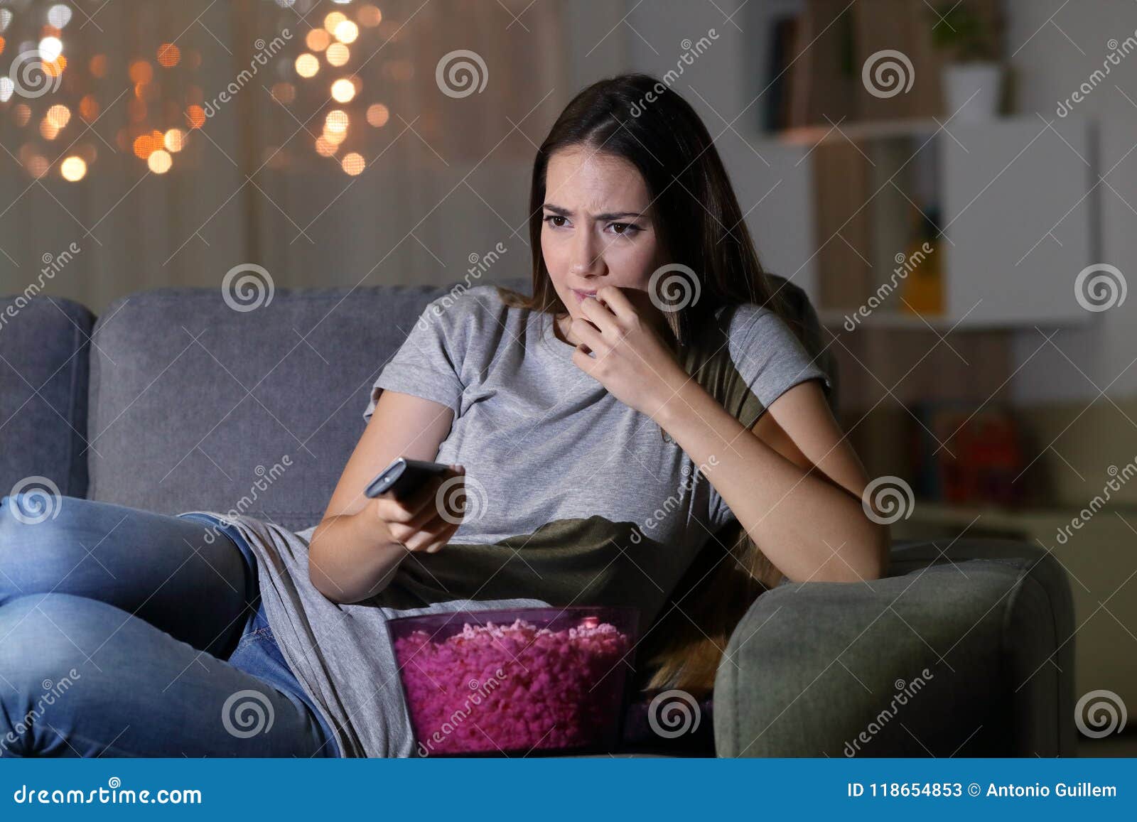 nervous spectator watching tv at home in the night
