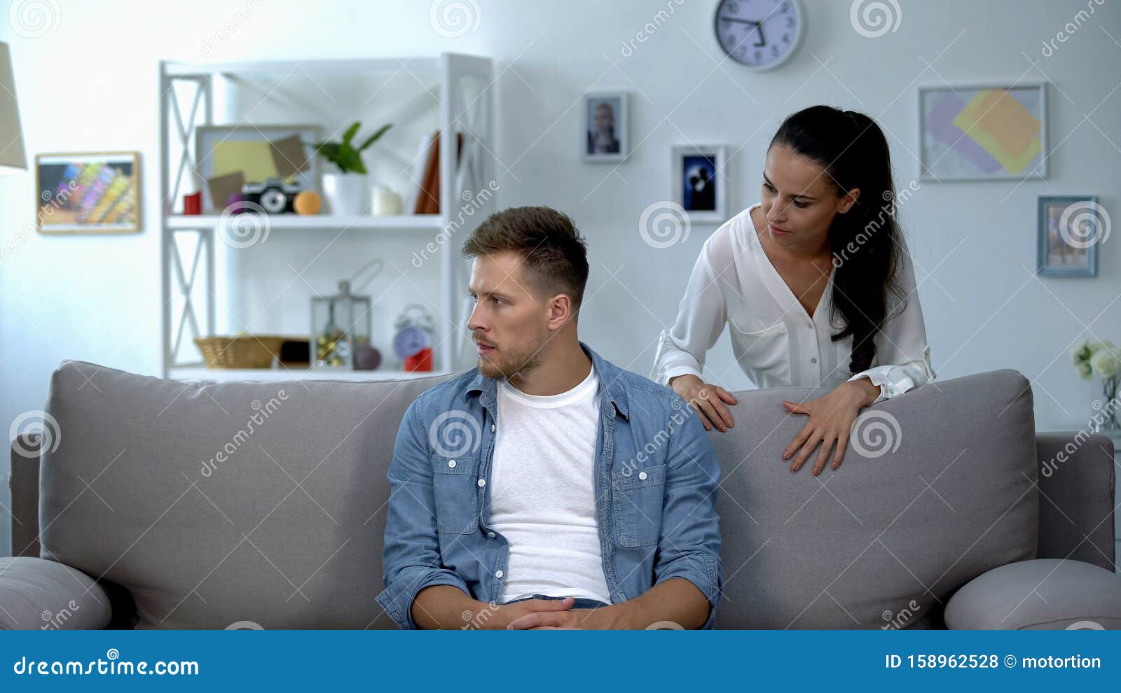 nervous woman criticizing lazy husband sitting on sofa, family conflict, problem
