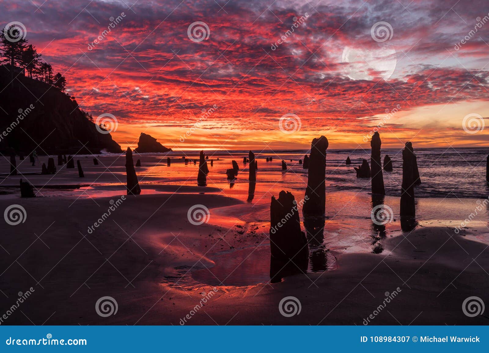ocean beach dramactic sunset and red sky water refleection