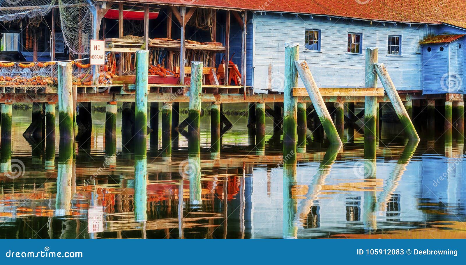 a net shed reflects in the puget sound at gig harbor