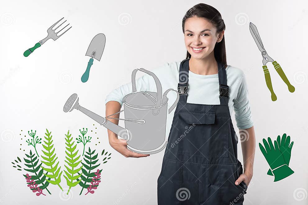 Netter Gärtner, Der Eine Gießkanne Hält Und Froh Schaut Stockbild