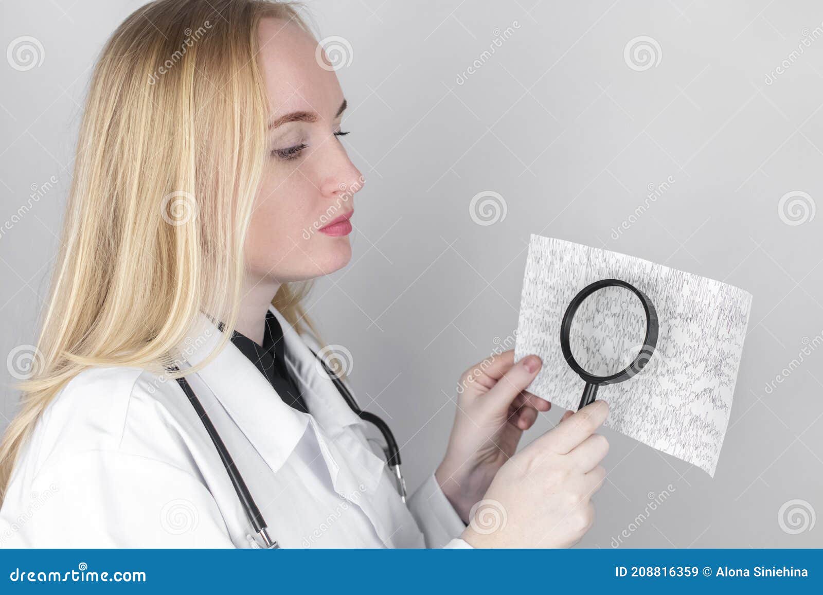 a neurologist with a magnifying glass examines an encephalogram of a patientÃ¢â¬â¢s brain. schedule of electroencephalograms - study