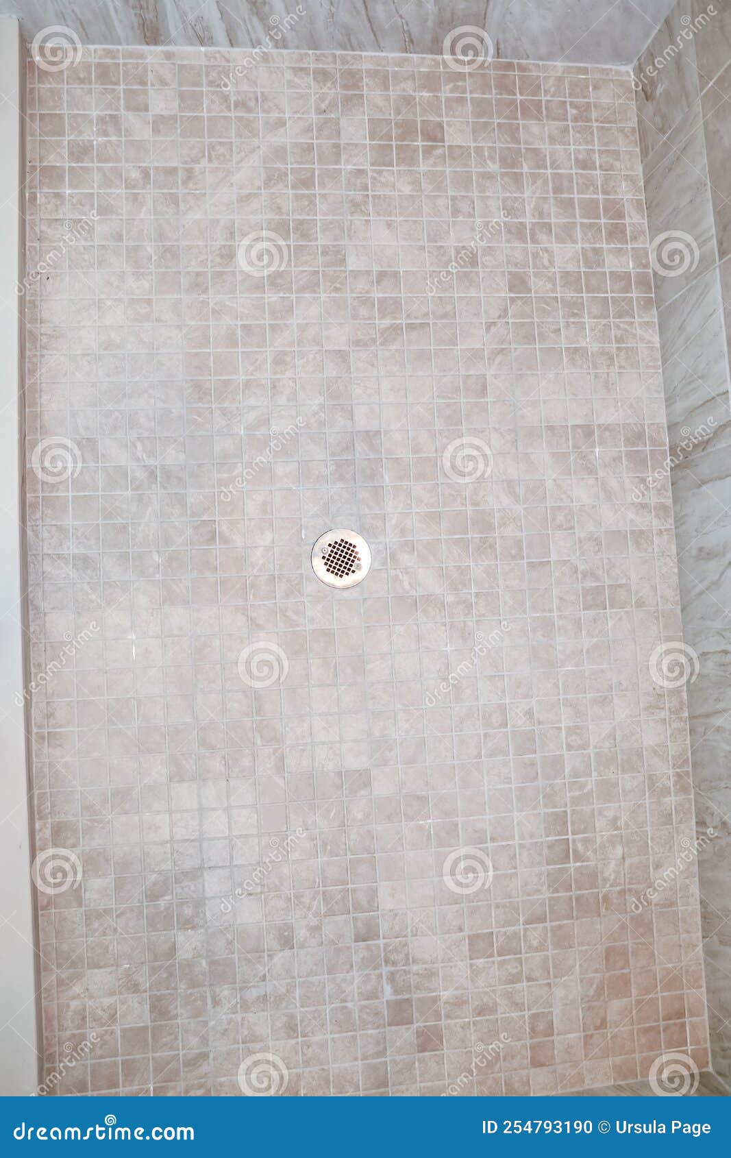 A Neutral Light Beige Square Tile Shower Floor with a Silver Metal