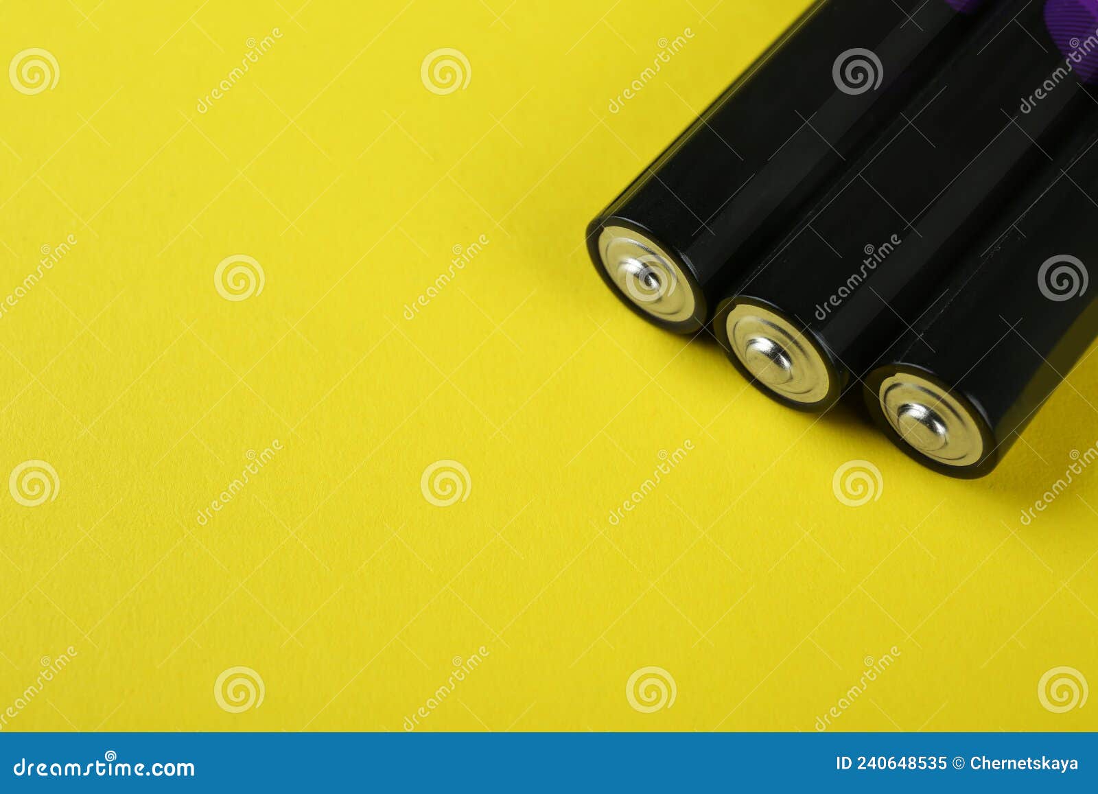 New AAA Batteries on Yellow Background, Closeup. Space for Text Stock