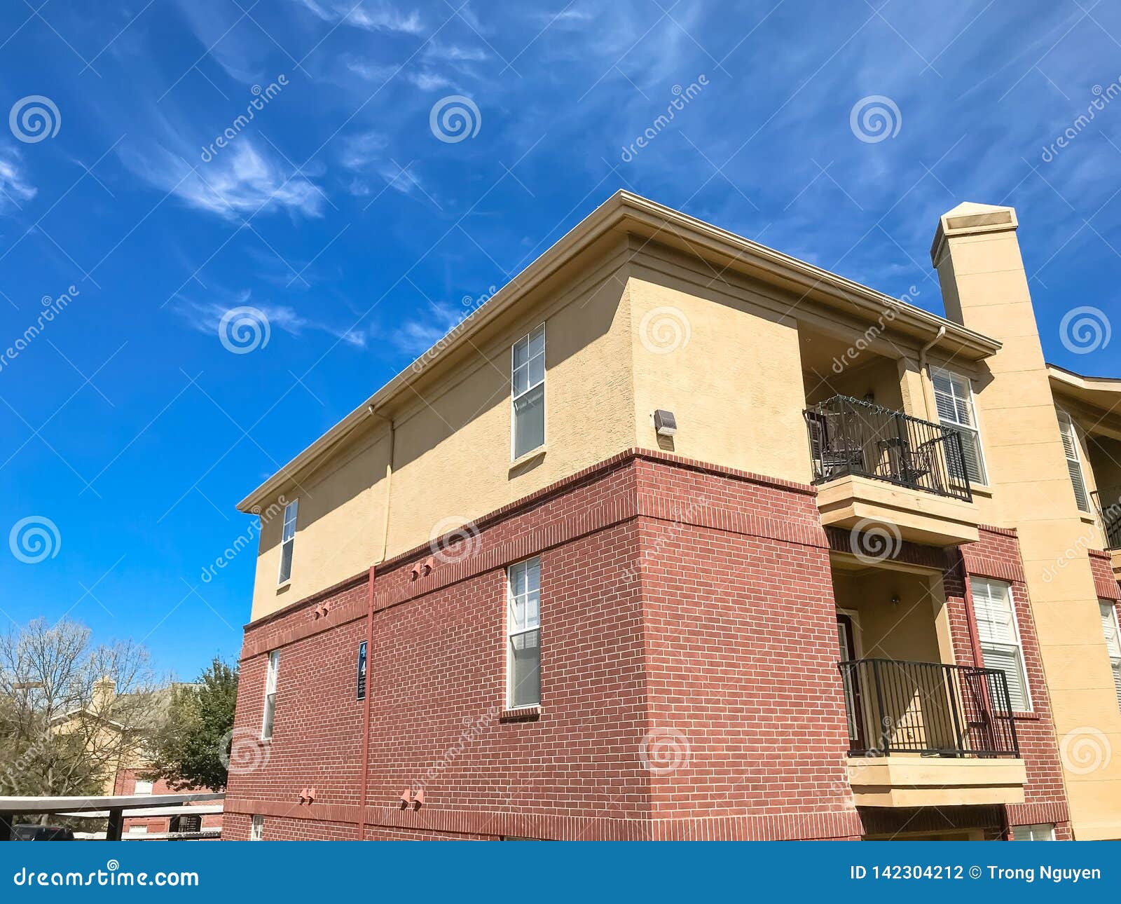 New Apartment Complex with Covered Parking Under Sunny Cloud Sky in