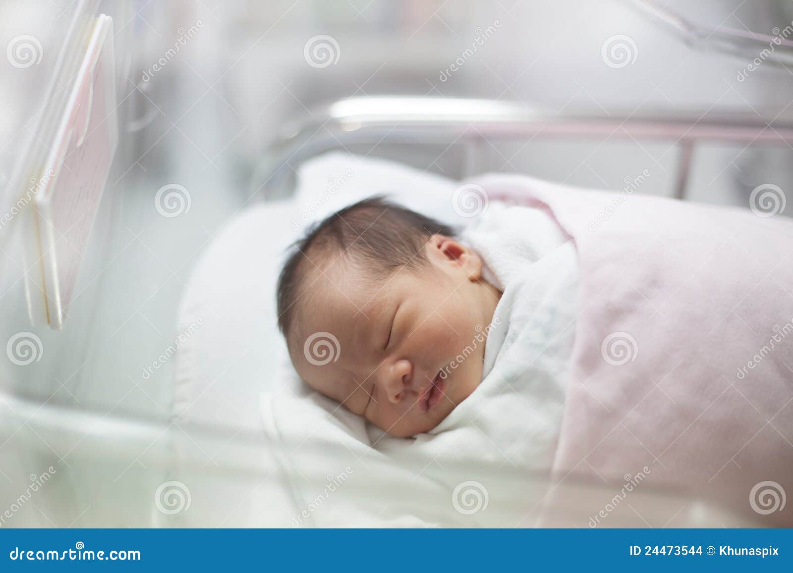 new born infant asleep in the blanket in delivery room