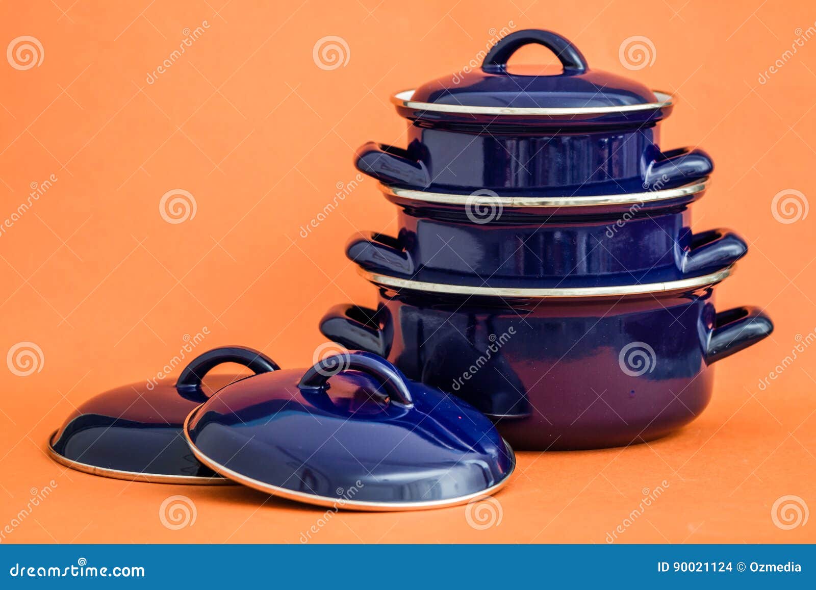 New and Clean Covered Dark Blue Saucepans on Orange Background Stock