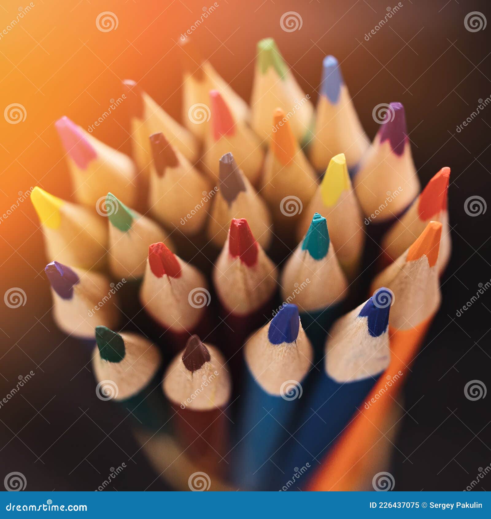 new color sharpened pencils on a dark background with sunlight or illumination. abstract background on a creative theme.