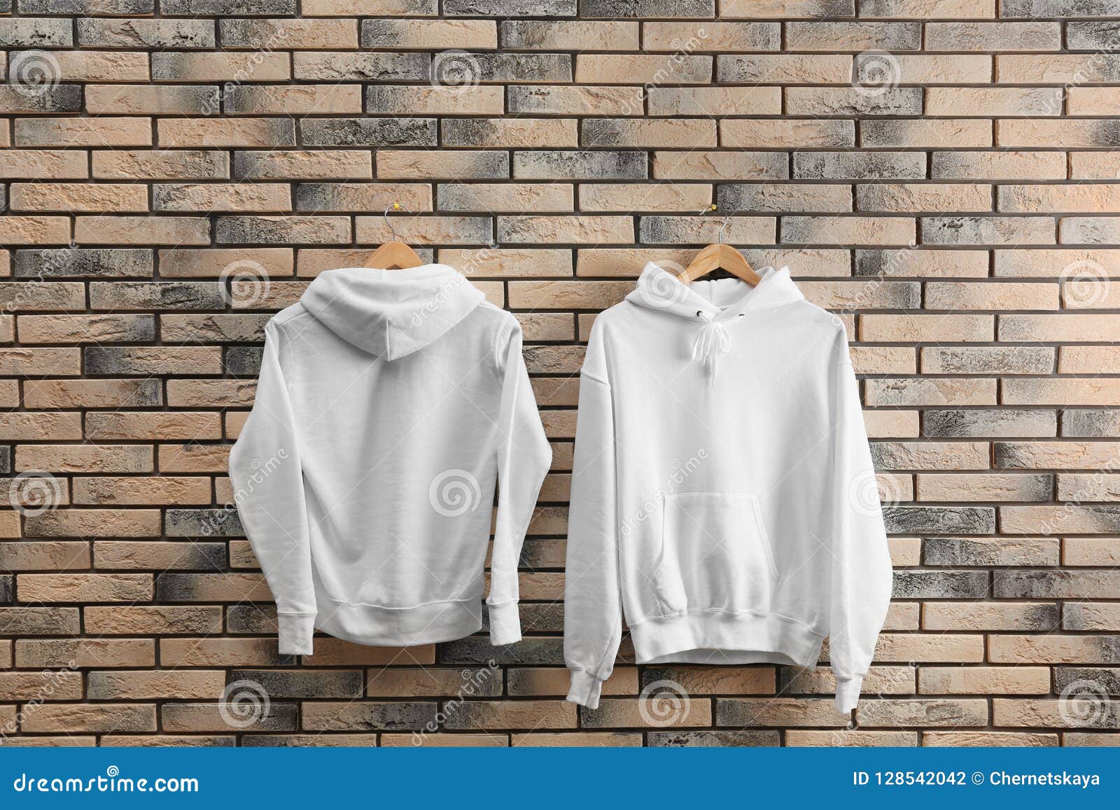 Download New Hoodie Sweaters With Hangers On Brick Wall Stock Photo ...