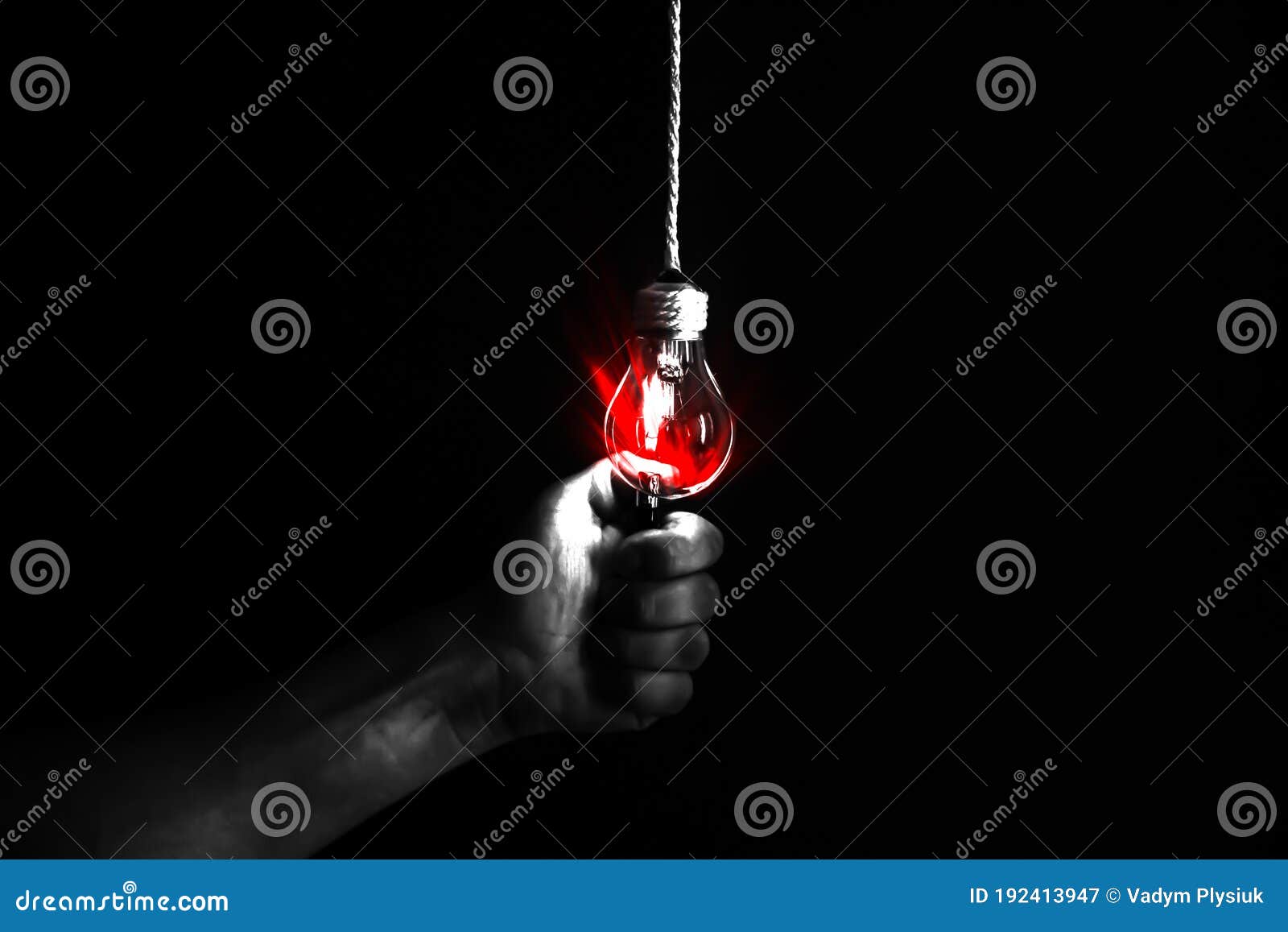 new idea concept. man is holding lightener near the lamp bulb. black background. red light