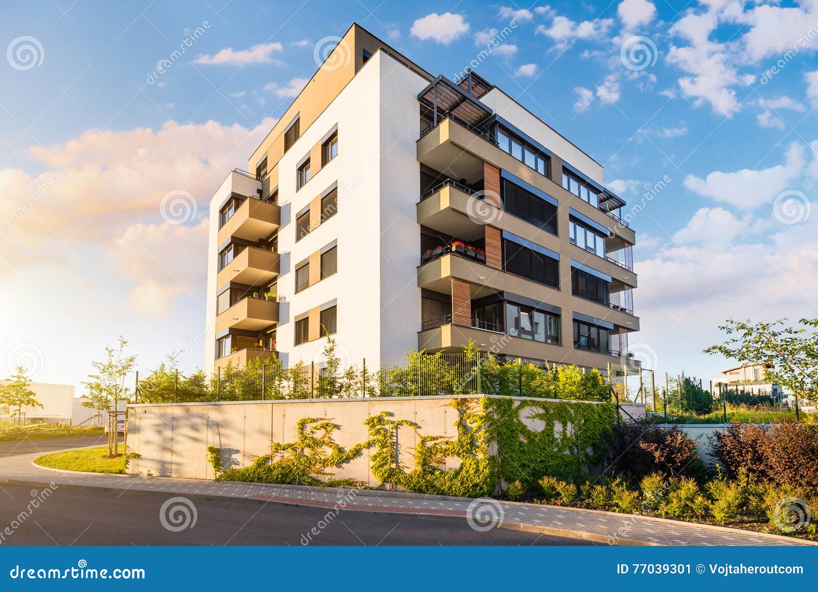 new modern block of flats in green area with blue sky