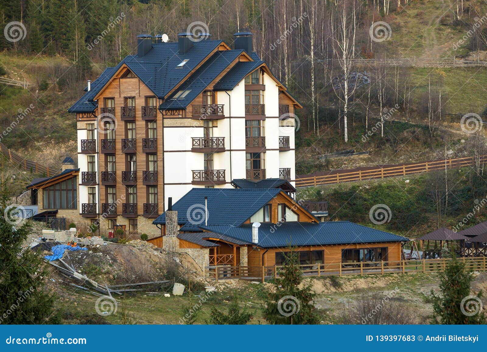 new modern comfortable four-story hotel building with attached premises, attic rooms and high chimneys in ecological rural area on