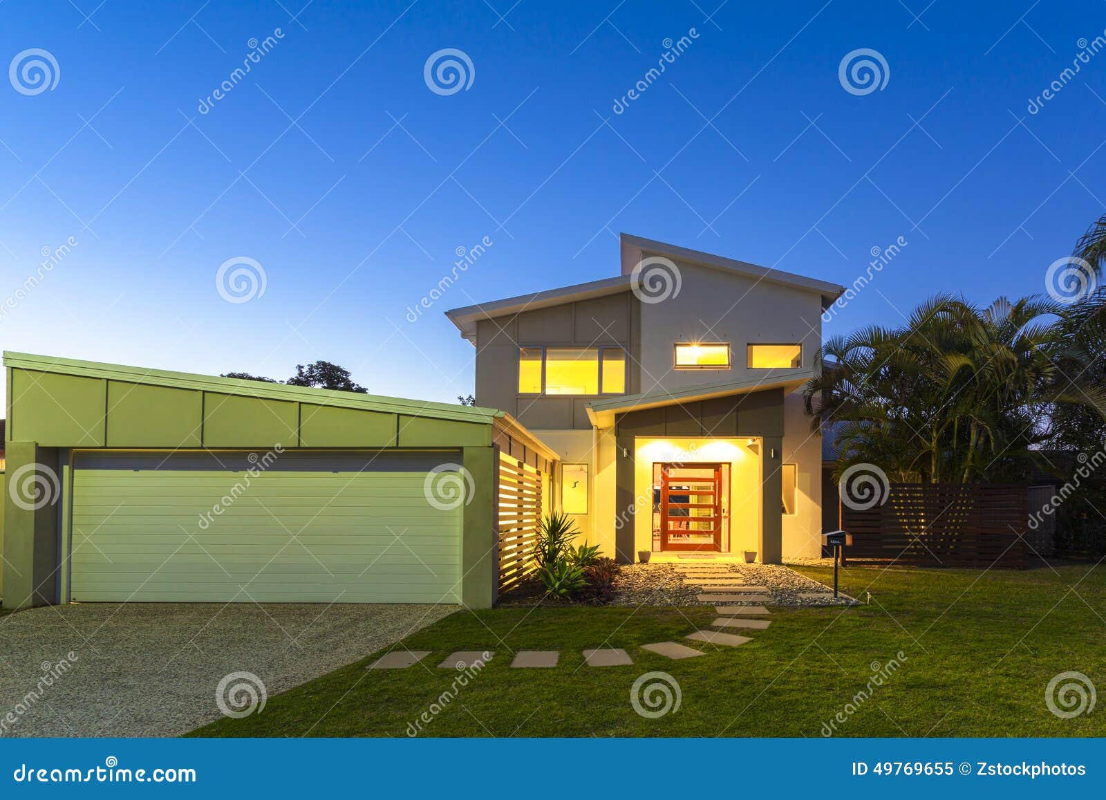 Modern House Exterior At Twilight. Luxury Villa With Garage. Stock