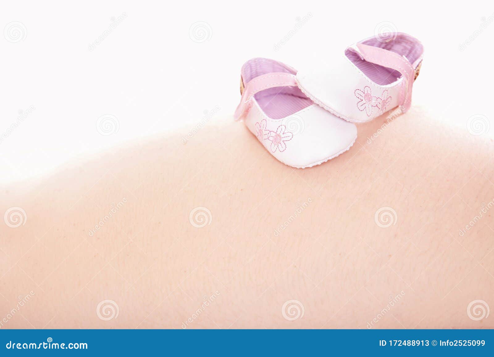 close up of pink baby shoes on white background