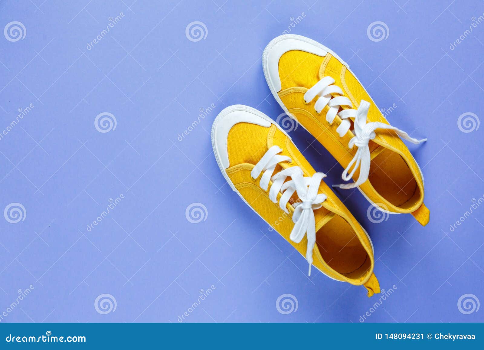 New Pair of Yellow Sneakers on Violet Background with Copy Space ...