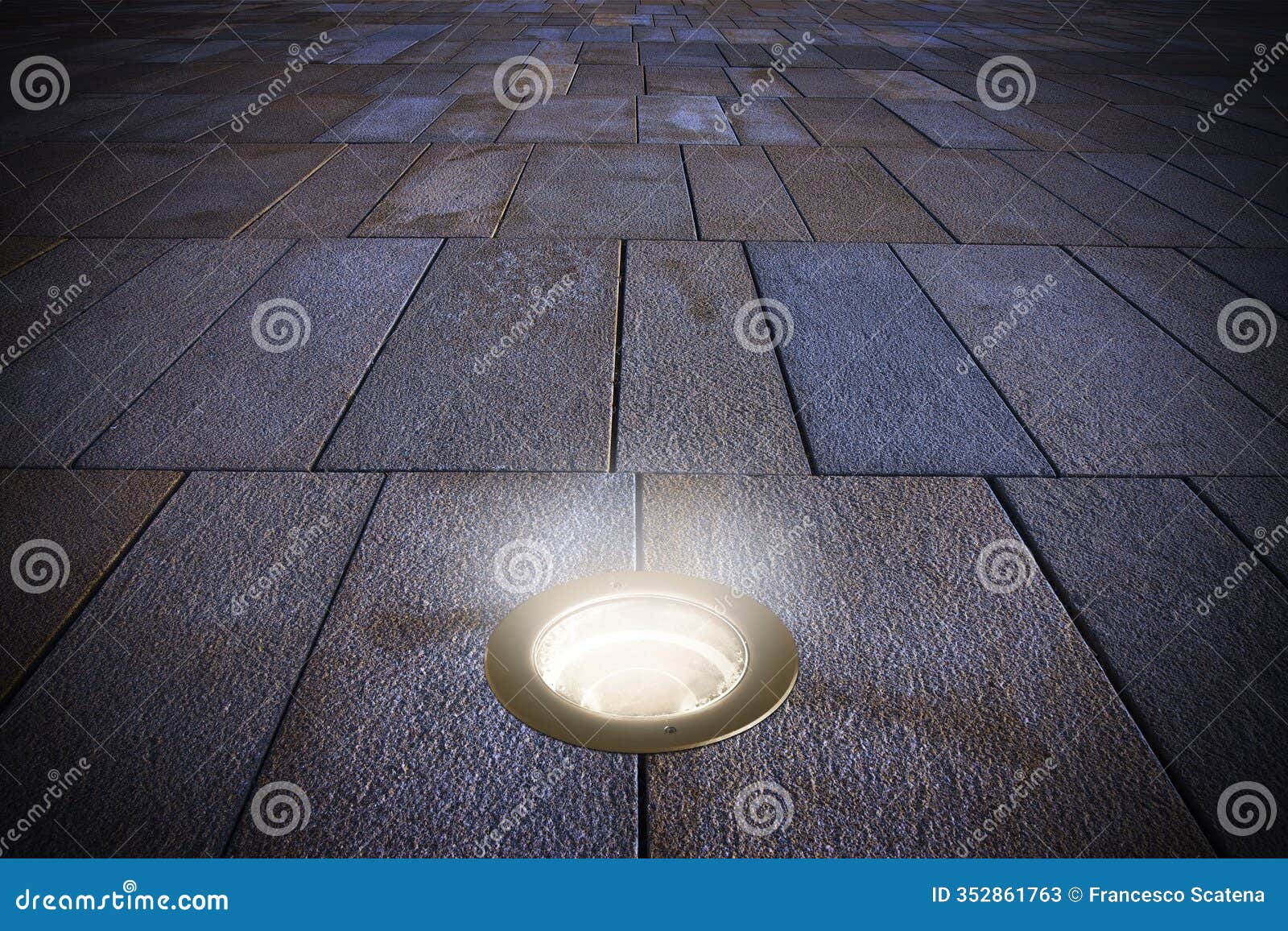 new paving made with stone blocks of rectangular  in a pedestrian zone with recessed floor lamp