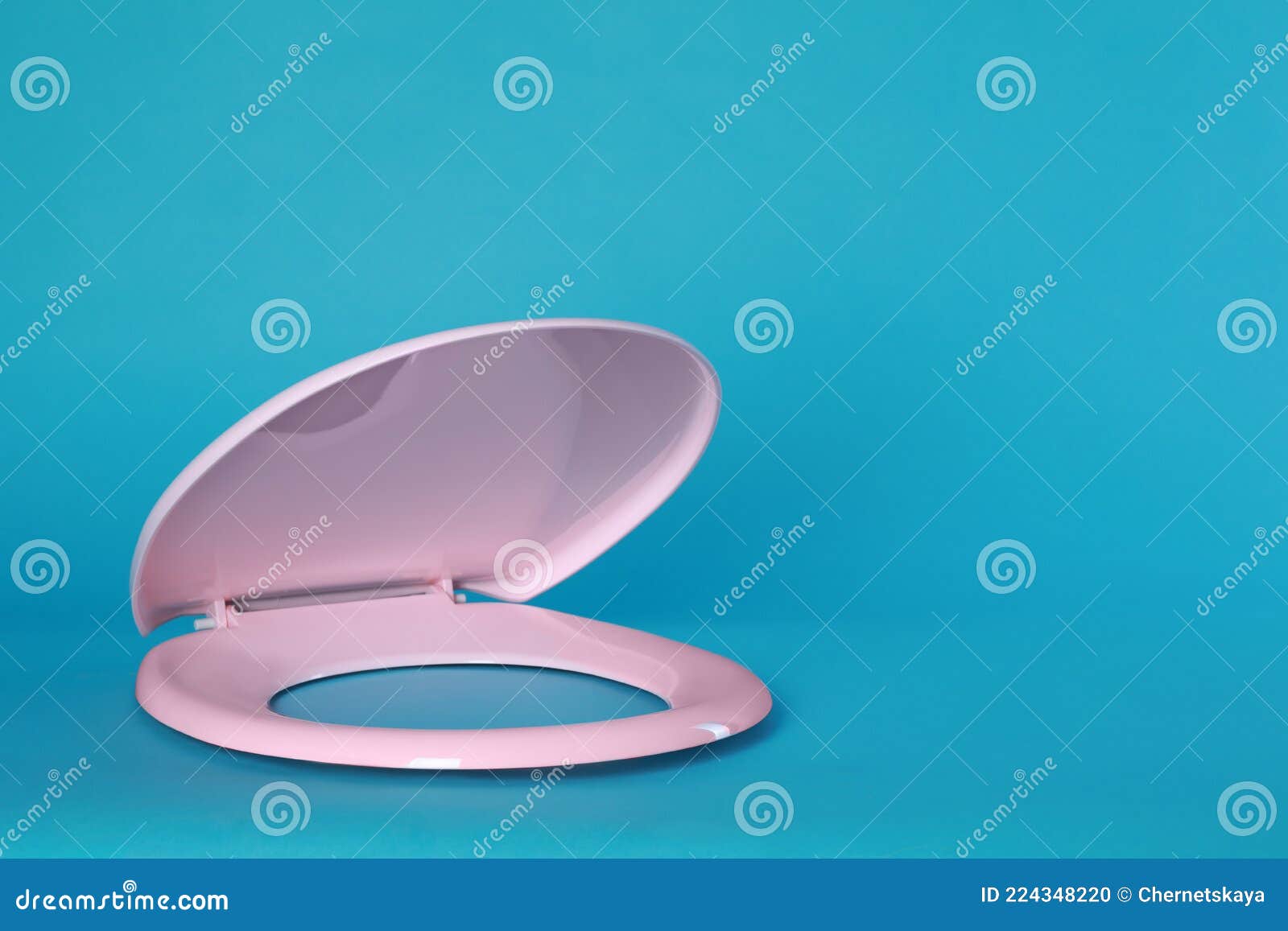New Pink Plastic Toilet Seat on Light Blue Background, Space for Text