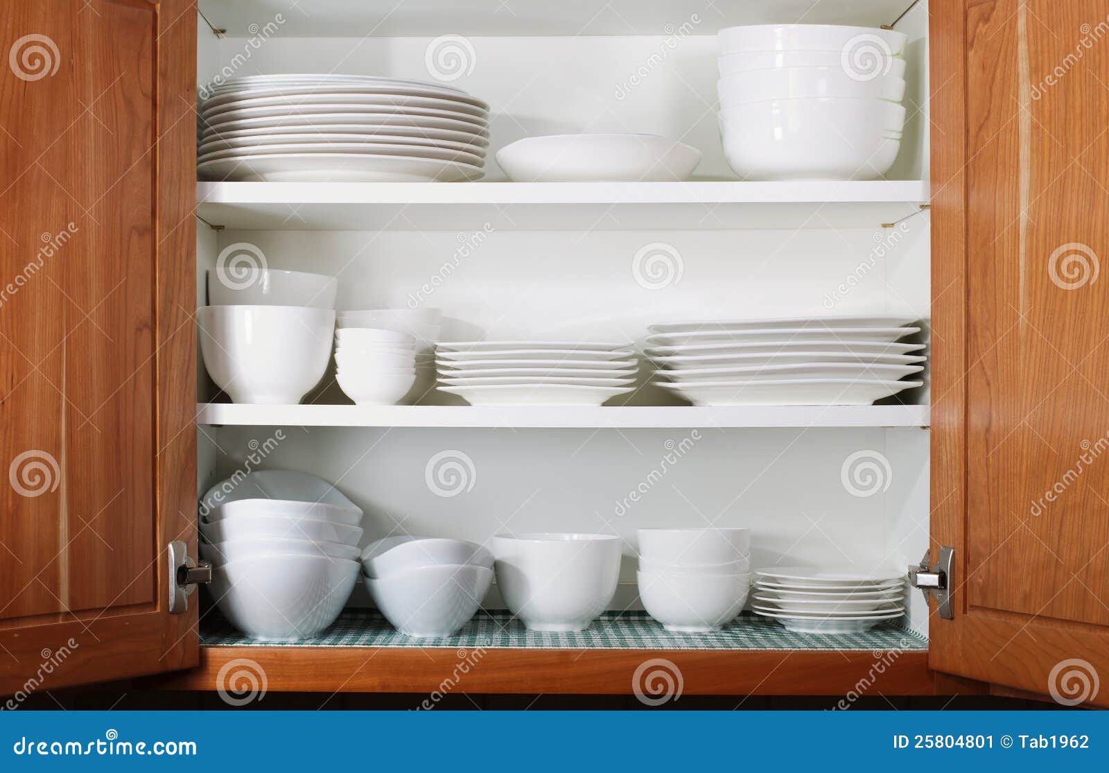 new white dishes and bowls in kitchen cabinet