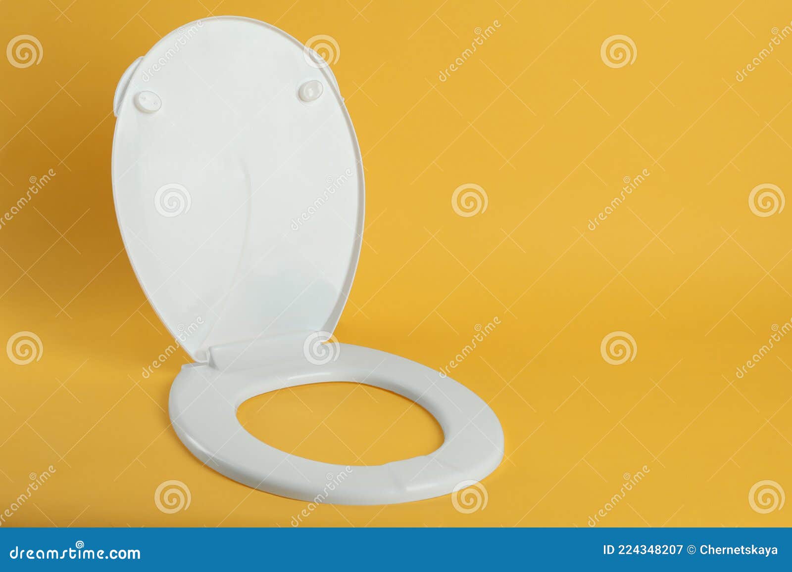 New White Plastic Toilet Seat on Yellow Background, Space for Text