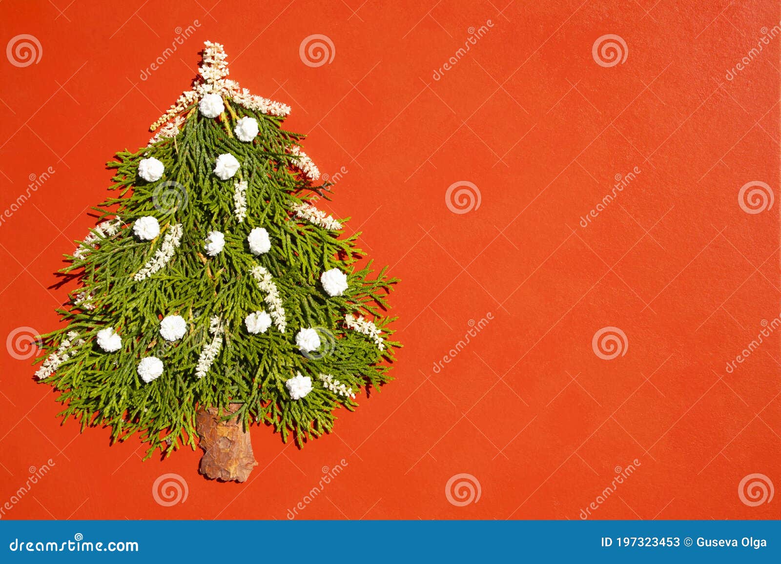 new year concept - alternative tree made of cypress branches on a red background with space for text. postcard template, poster