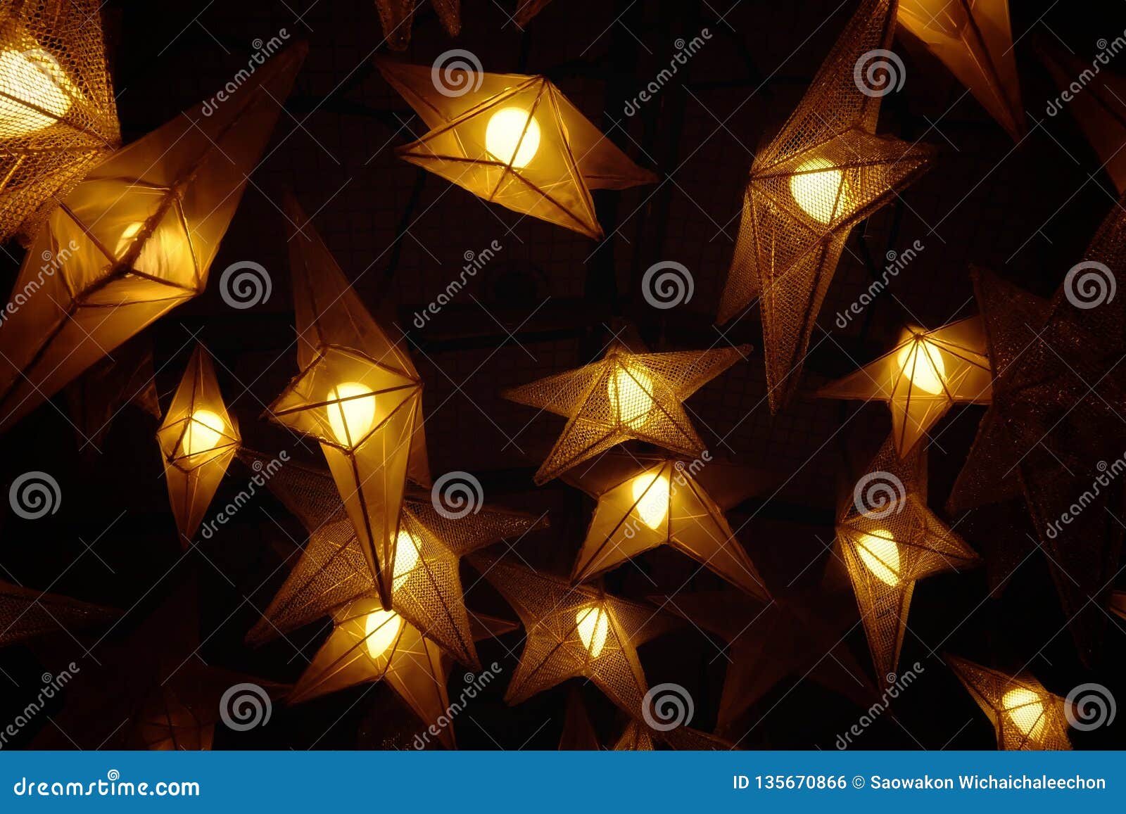 Many Star Lamps Hanging From The Ceiling And Glowing In The Dark