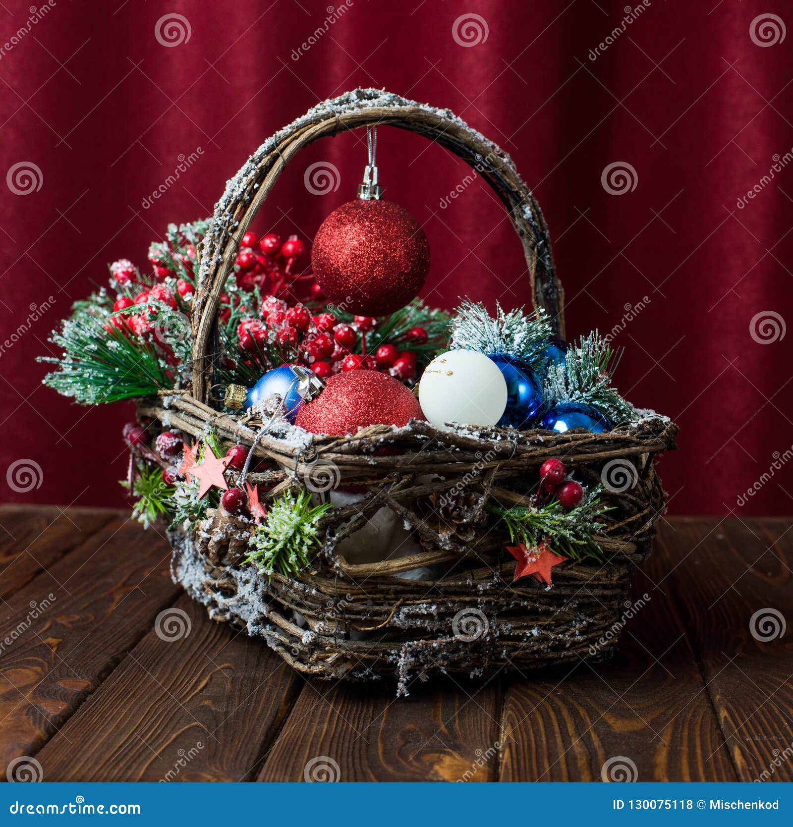 New Year`s toys in a basket on a wooden background. Christmas toys. Gift basket with Christmas lights. Christmas toys.