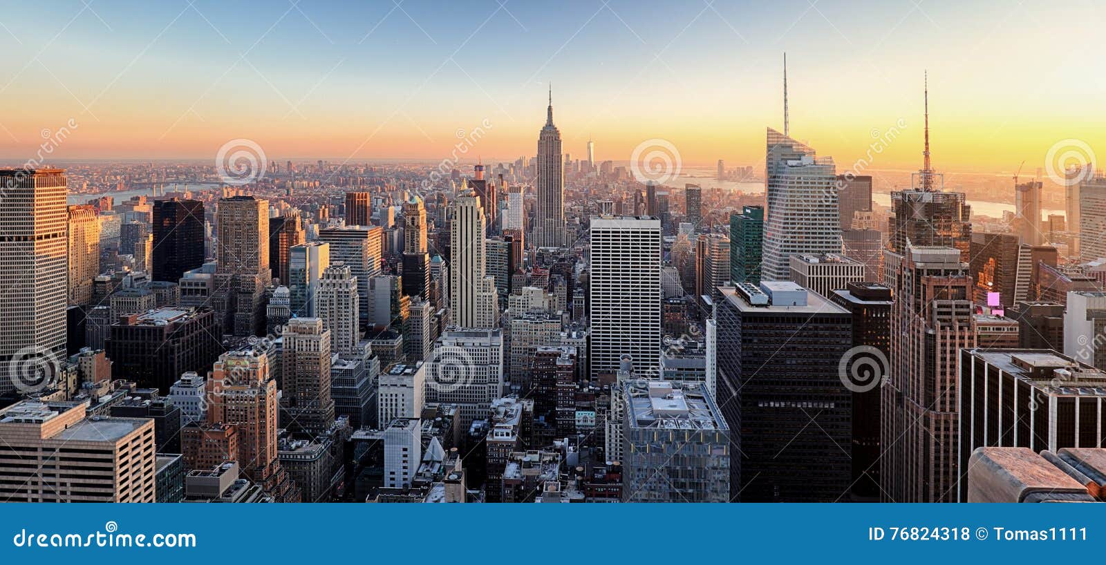 new york city. manhattan downtown skyline with illuminated empire state building and skyscrapers at sunset.