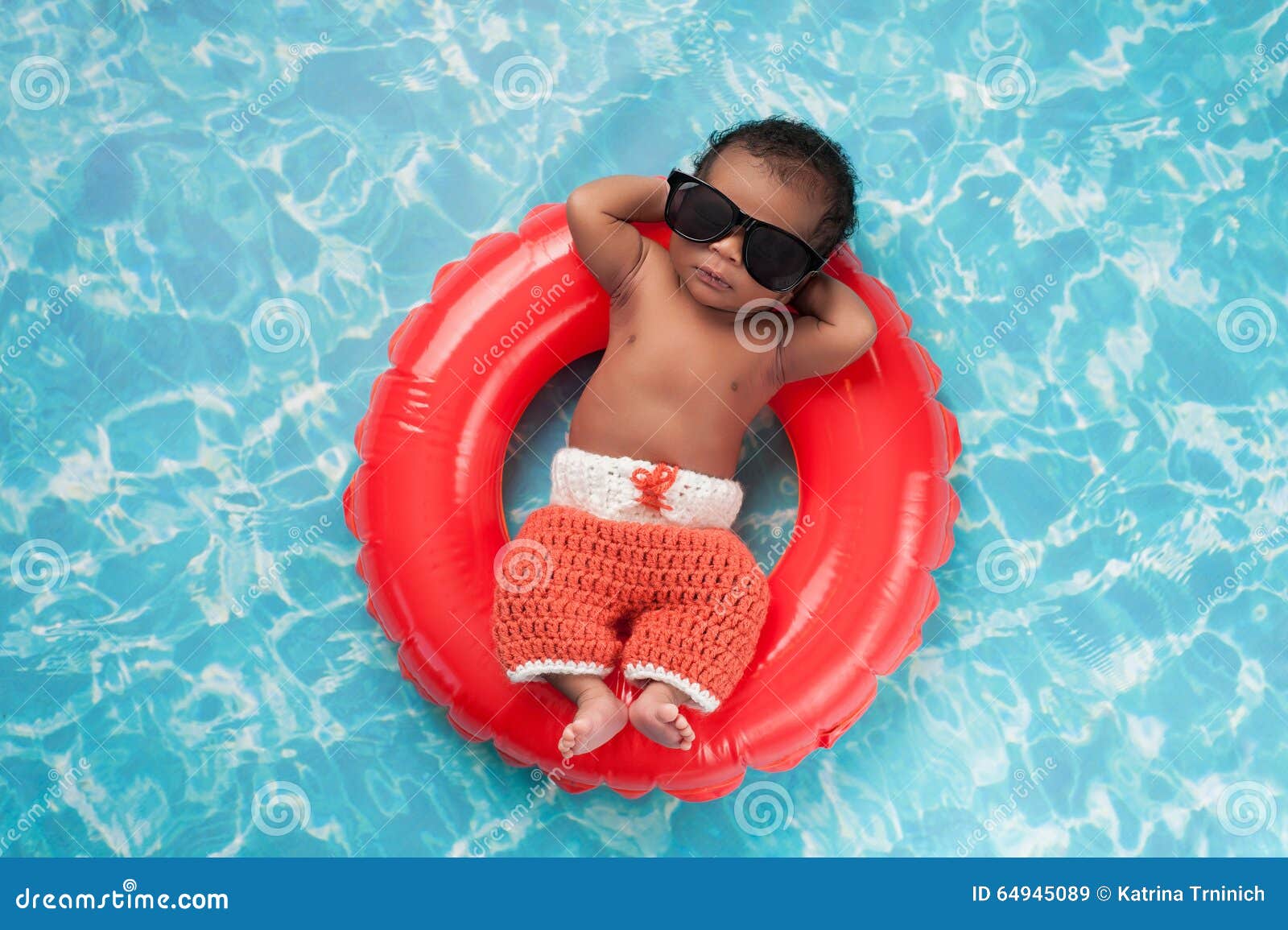 newborn baby boy floating on a swim ring