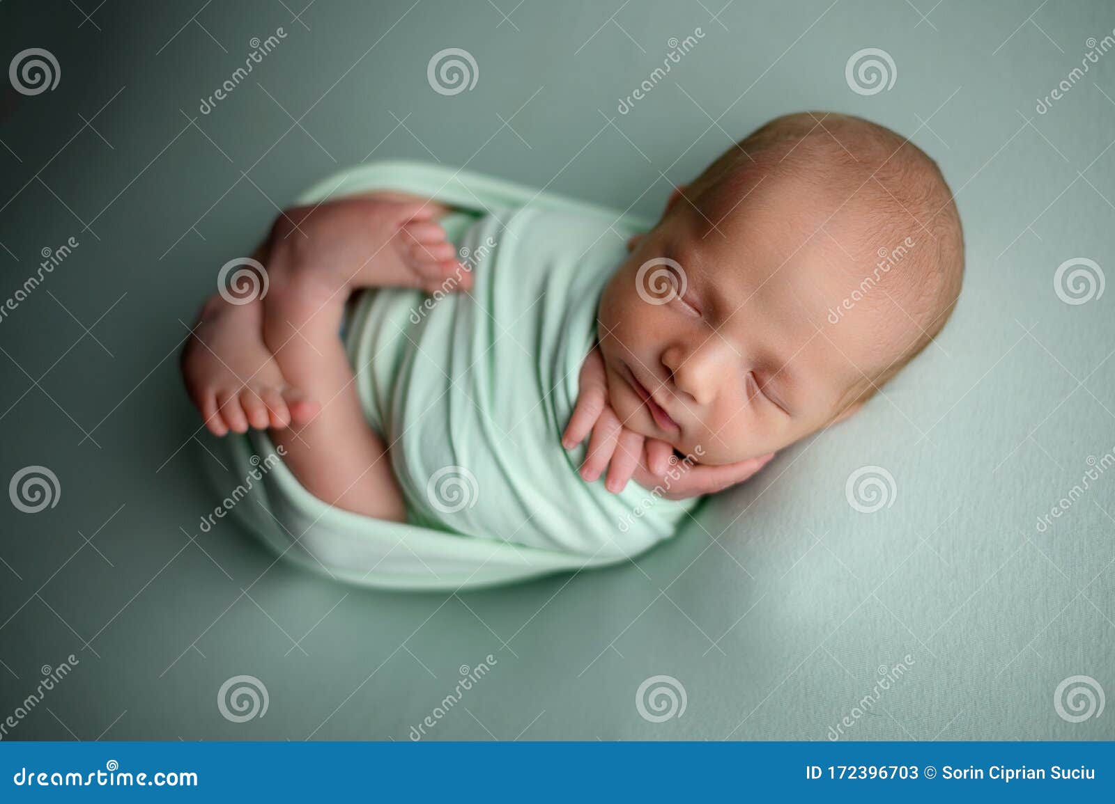 newborn baby boy sleeping confort pose on a beanbag
