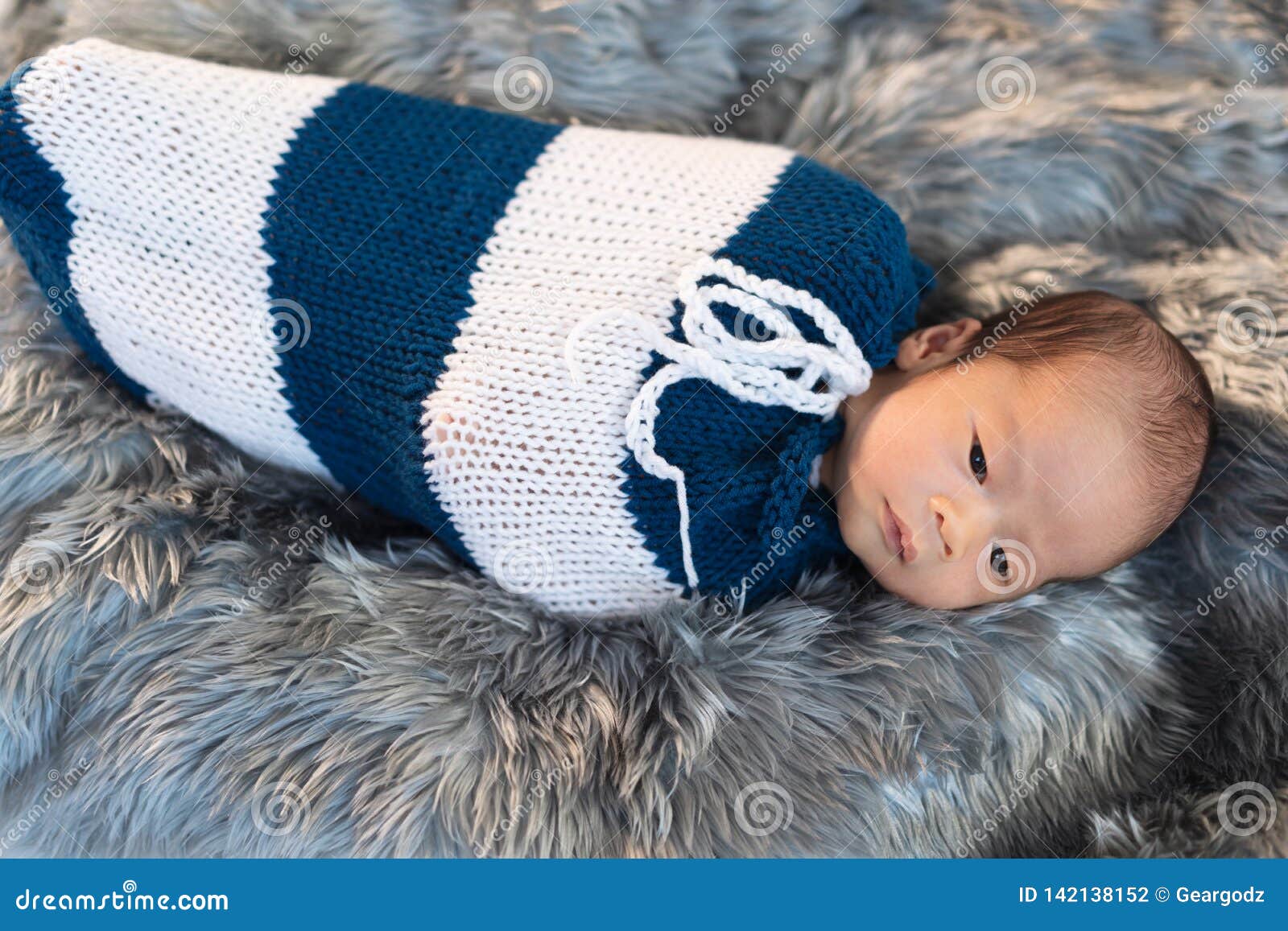 Newborn Baby Boy Swaddled In A Knit Wrap On Fur Bed Stock Photo Image
