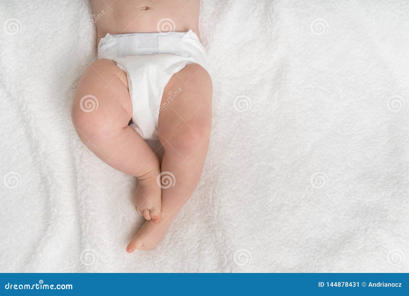 newborn baby in diaper lying on white blanket